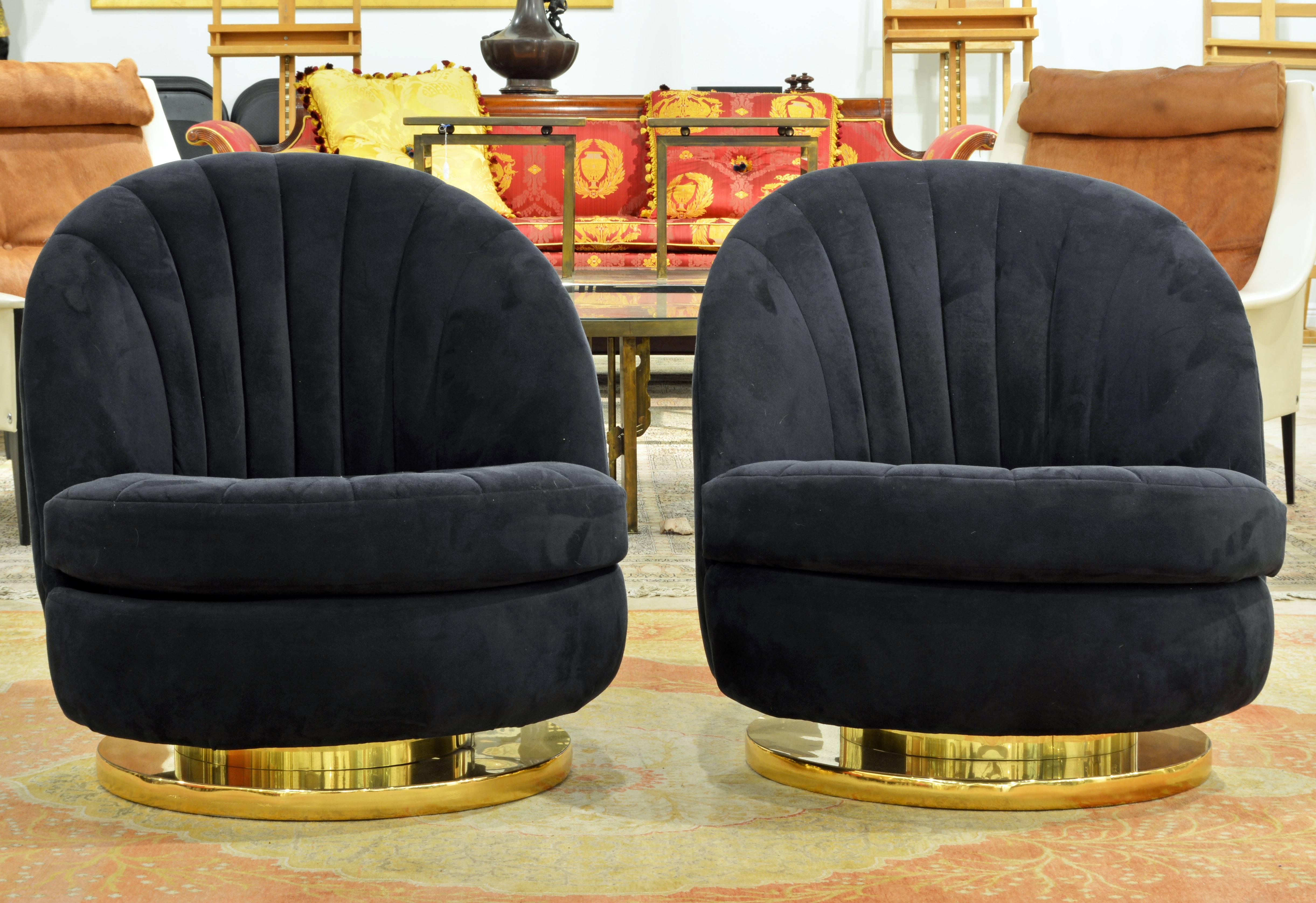 This attractive Mid-Century Modern pair of iconic lounge chairs are covered with blue micro suede in immaculate condition. Resting on a circular brass and chrome base the chairs turn 360 degrees and at the same time tilt to accommodate maximum