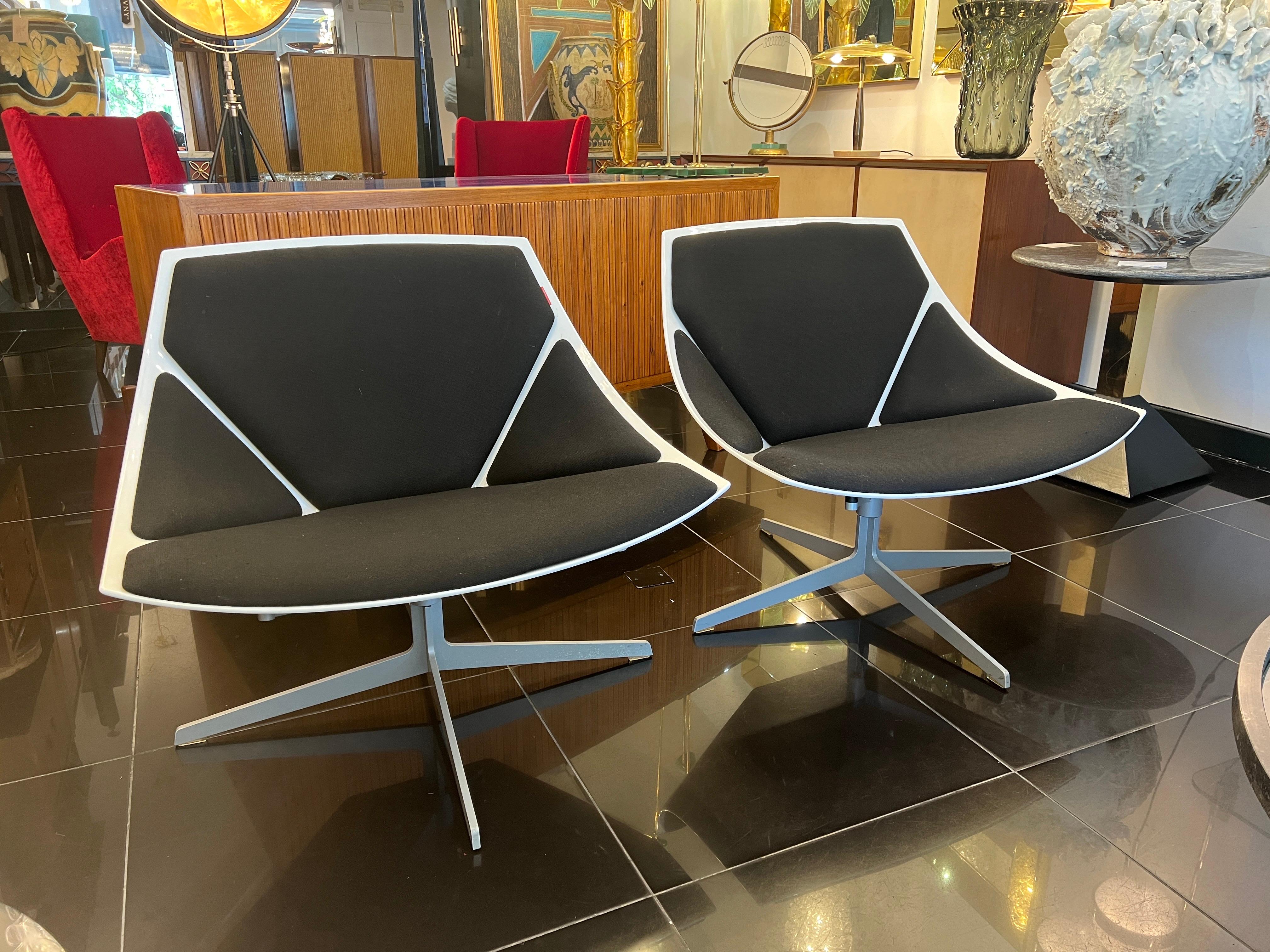 Danish modernist pair of swivel chairs with curved seat and backrest upholstered in black fabric on a structure made from white lacquered synthetic material with steel support. 
Manufactured by Fritz Hansen . Denmark 