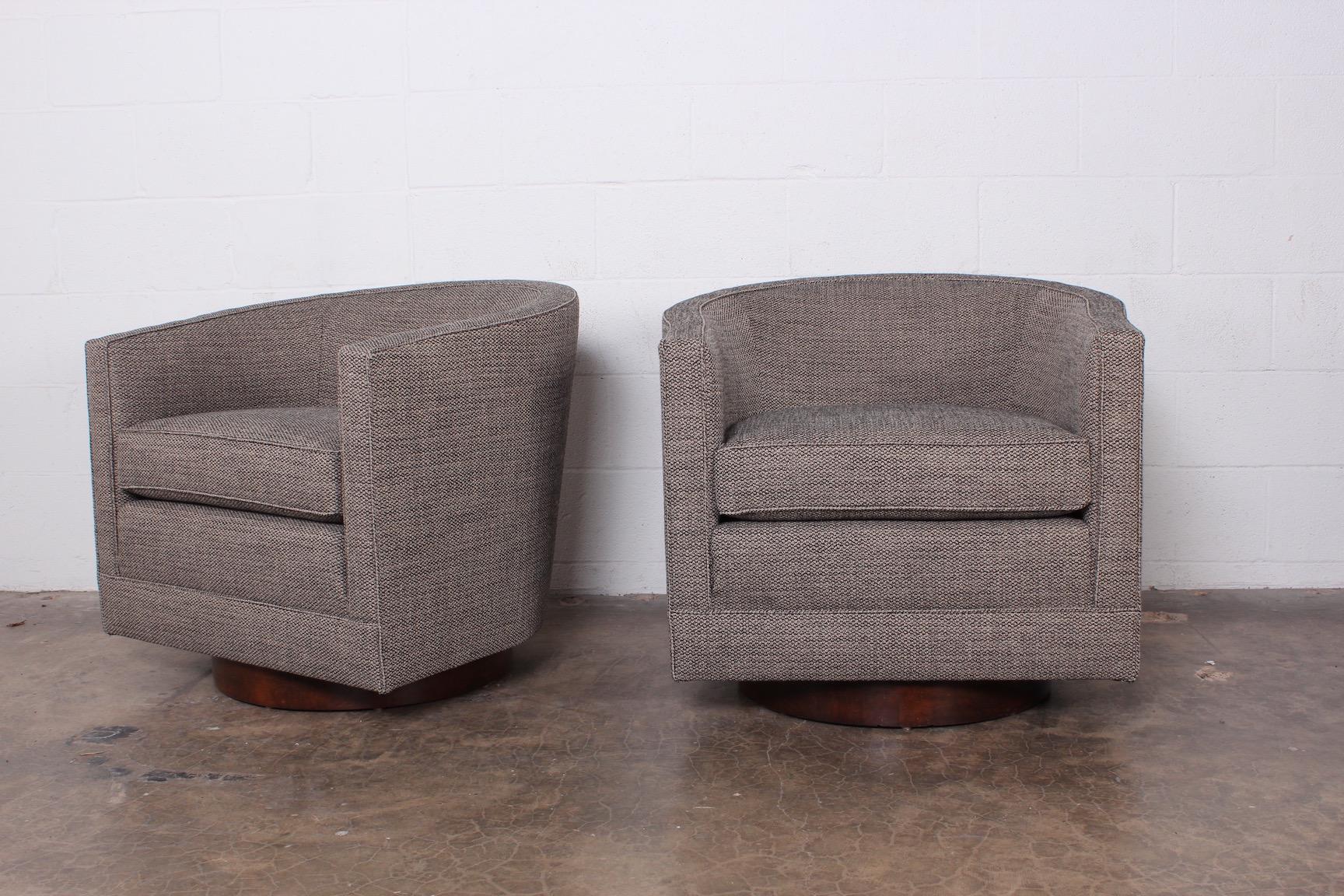 A pair of swivel chairs on walnut bases designed by Edward Wormley for Dunbar.
 