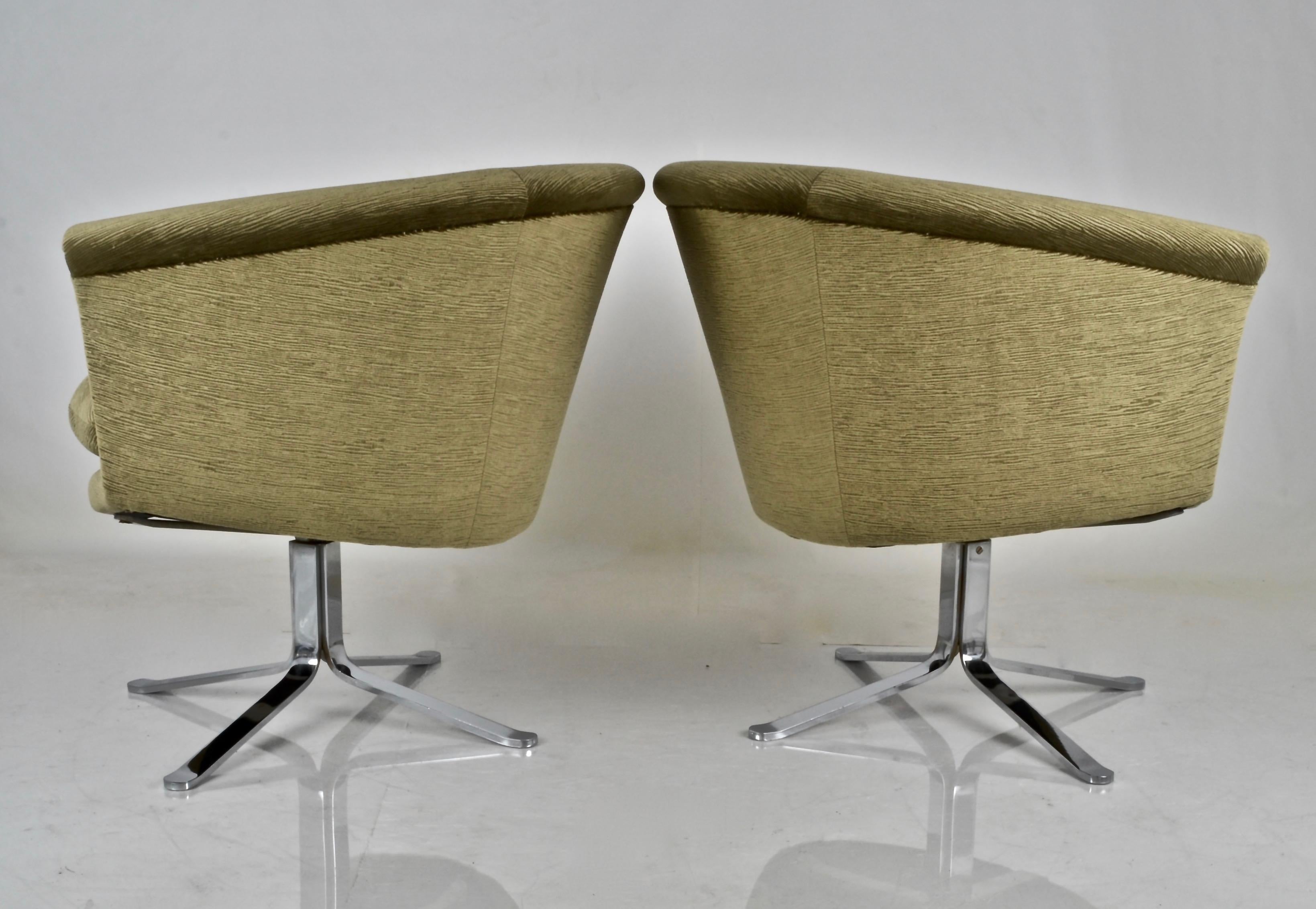 A pair of swivel based barrels chairs by noted designer and artist Nicos Zographos. Newly upholstered in moss grey/green random ribbed fabric. Loose seat cushions. Polished heavy steel bases.