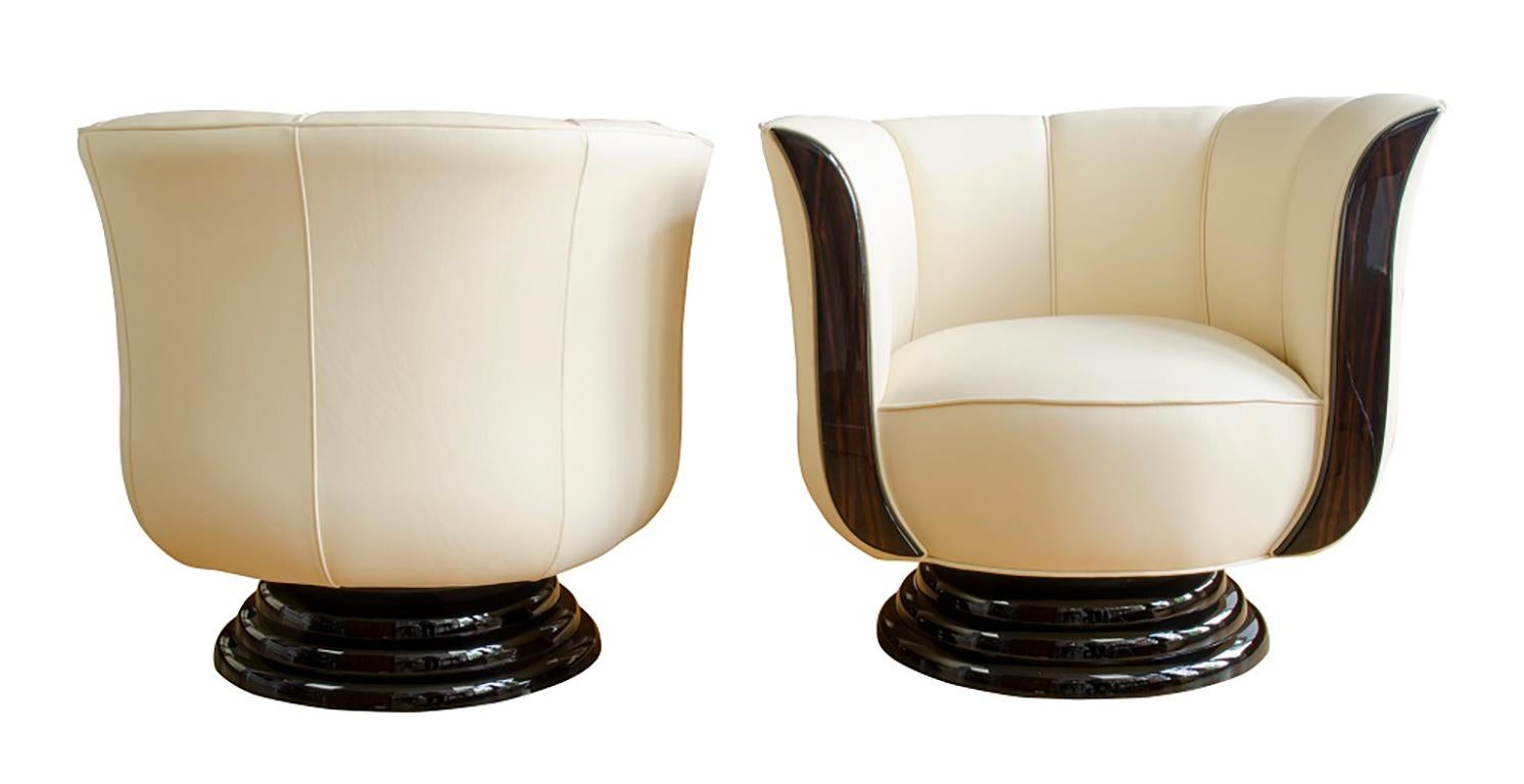 Pair of Art Deco swivel armchairs
Das beschriebene Paar Drehsessel sind Neuanfertigungen im Art Déco-Stil. Sie sind mit hochwertigem, goldfarbenem Leder in Reptiloptik bezogen und aufwendig gepolstert. Die Blenden in hochwertigem Edelholz furniert