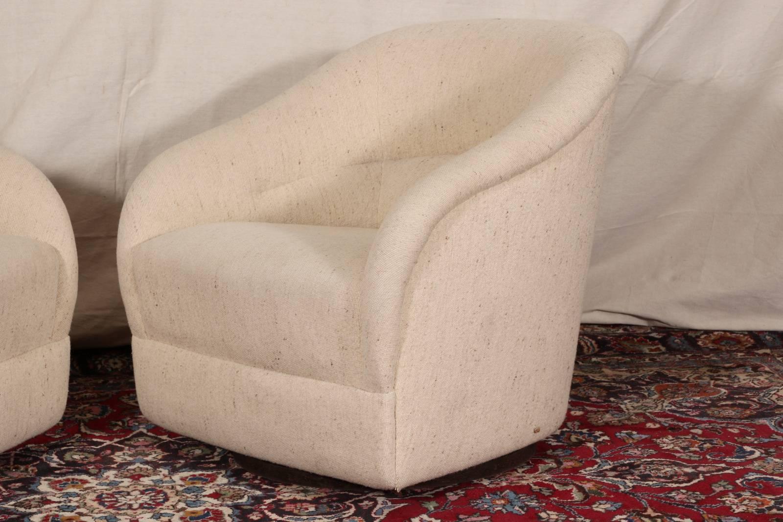 Pair of swivel club chairs, upholstered in a neutral tone speckled slub fabric, with rolled backs. Good weight and great form.

Condition: Expected wear and signs of use, some wear to upholstery ,staining to one seat. This pair will need