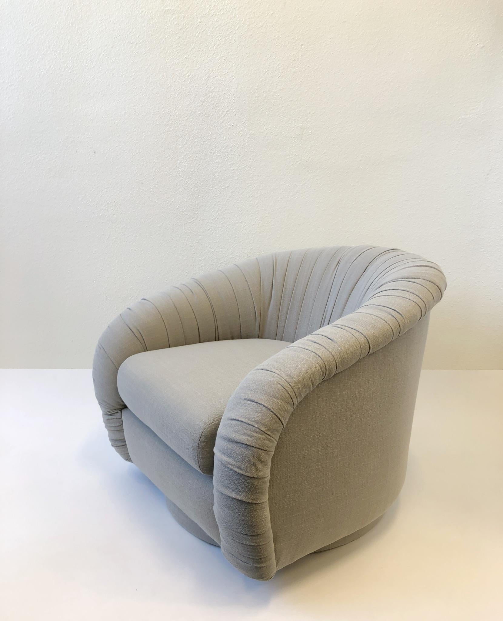 A pair of glamorous 1980s swivel lounge chairs in the manner of Milo Baughman. Newly recovered in light grey cotton fabric. The chairs rotate 360.
Dimensions: 34” wide, 34” deep, 17” seat, 28” high.