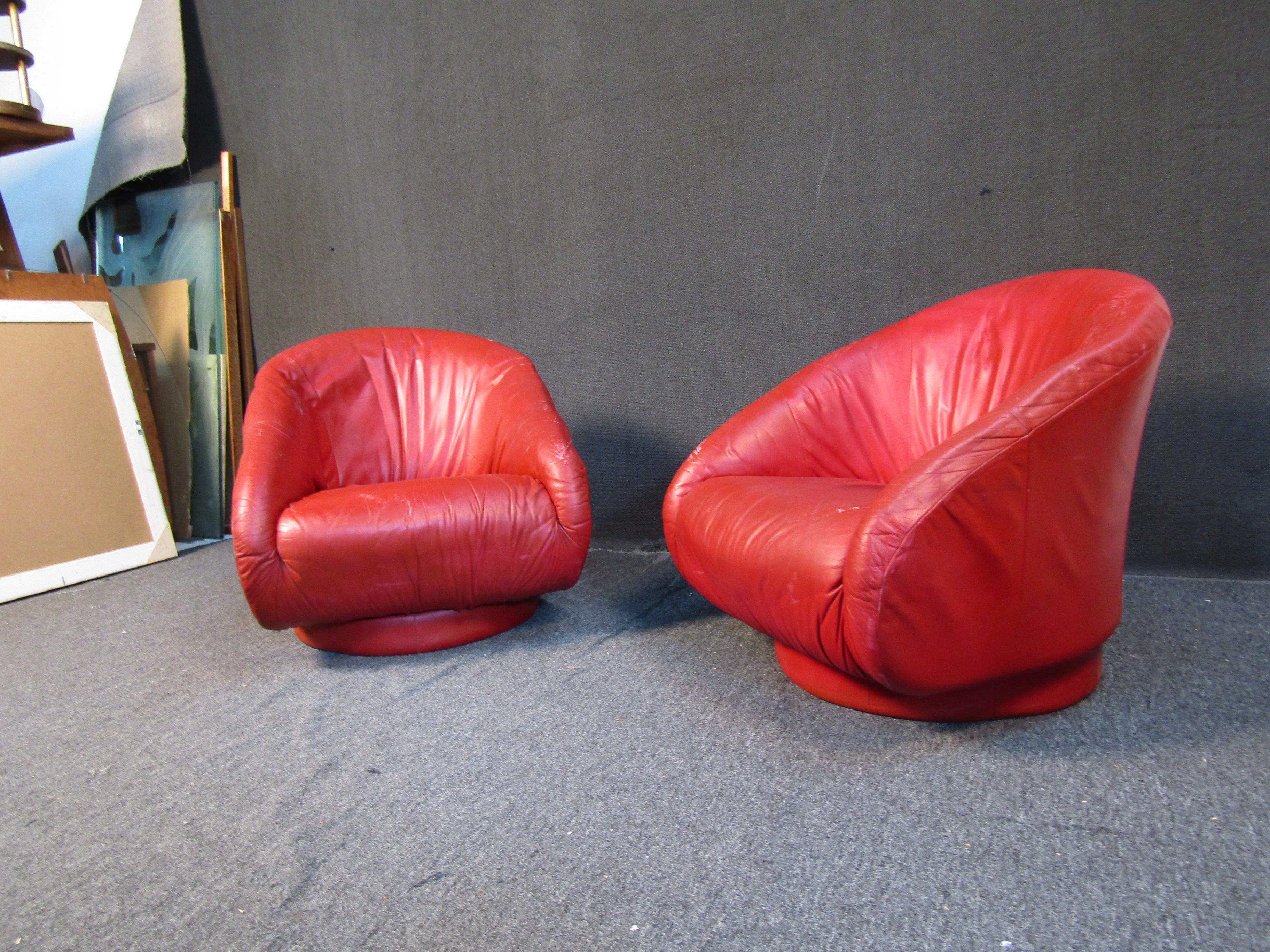This pair of comfortable, oversized club chairs sit on swiveling bases and are completed by a bright red, durable upholstery. Please confirm item location with seller (NY/NJ).