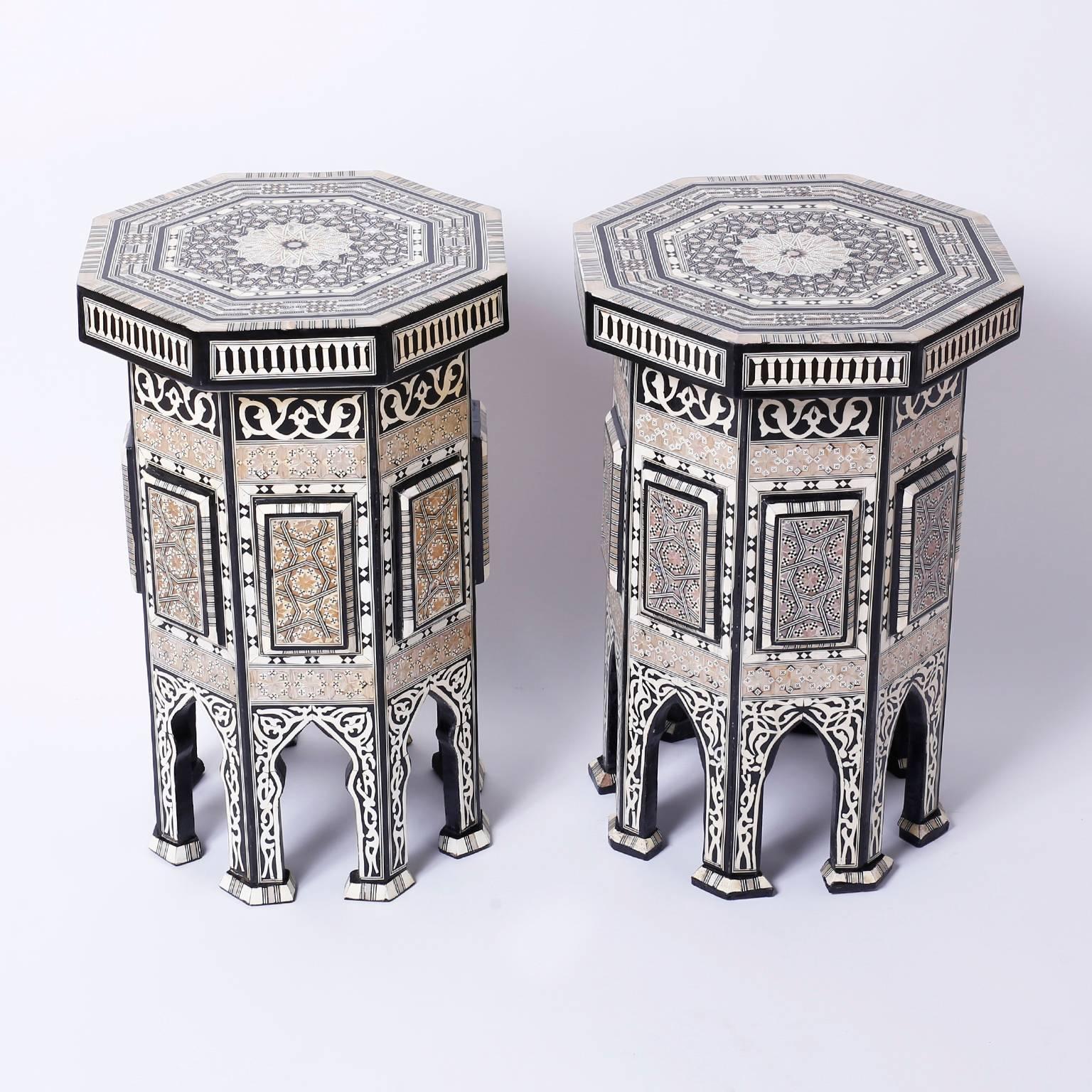 Lofty pair of antique Syrian octagon end tables or stands elaborately
decorated with inlaid mother of pearl. Bone and exotic hardwoods in
floral and geometric patterns adorn all eight sides and tops. The feet
are moorish ashes which complete the