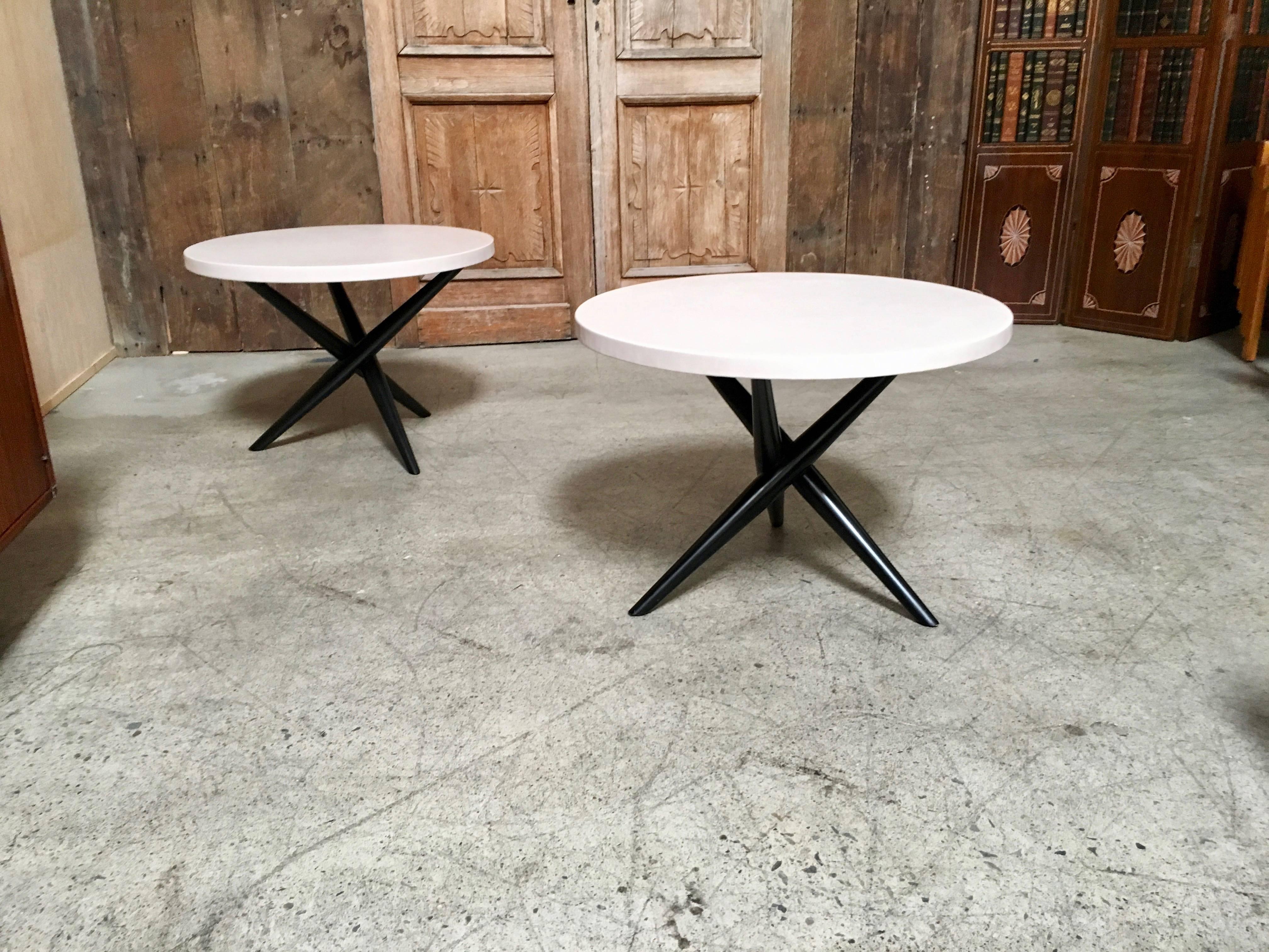 Pair of jax tables with ebonized base and creamy ivory leather top.