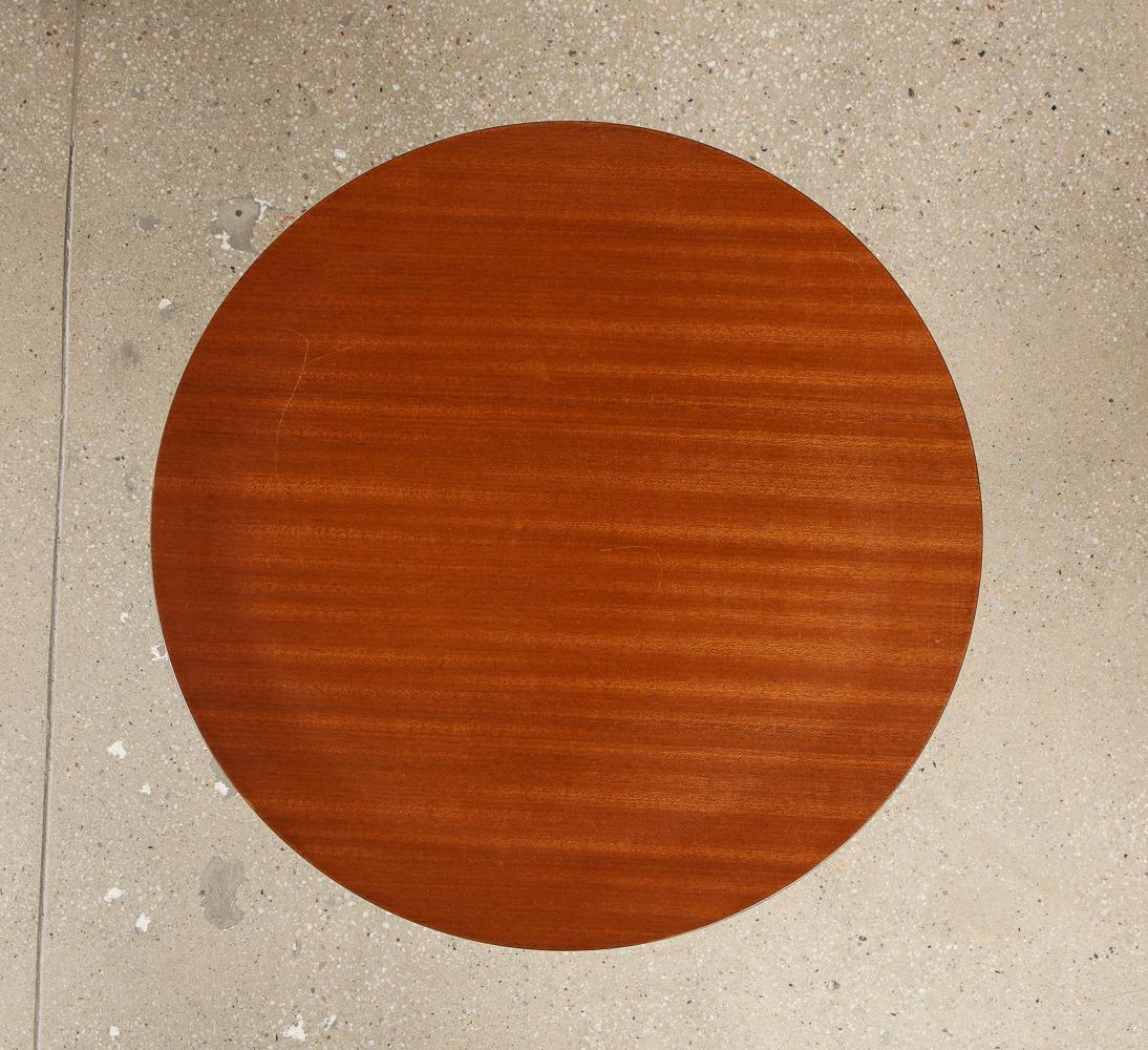 Painted metal, mahogany, brass. 3-legged architectural side tables with circular wood tops and maker’s label to each stem.