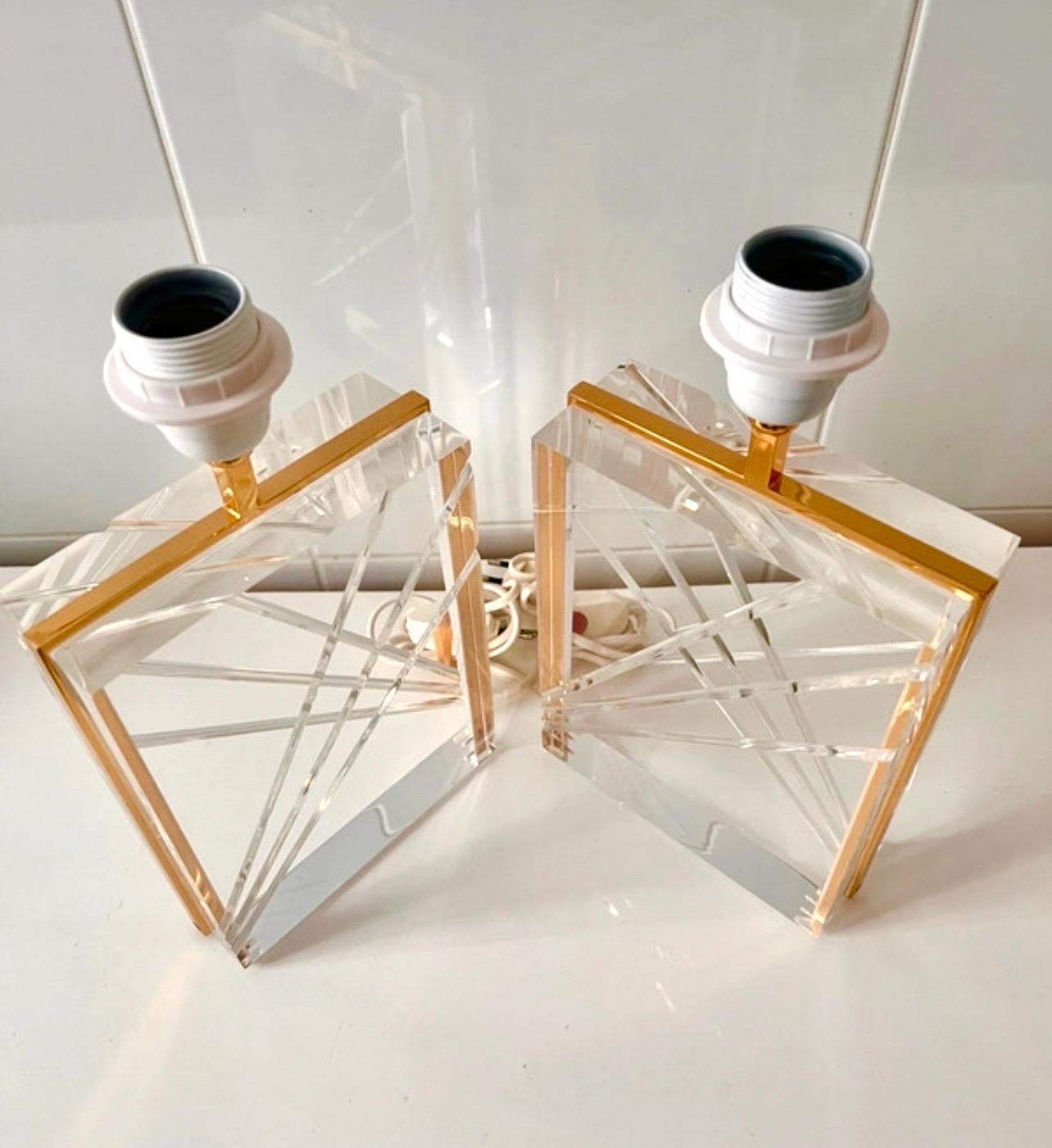 Pair of Italian Lucite lamps with gilded structure from the 1970s with grooved details, on a gilded brass base. Chic and elegant model of high quality. An iconic model reference in all reference interiors.