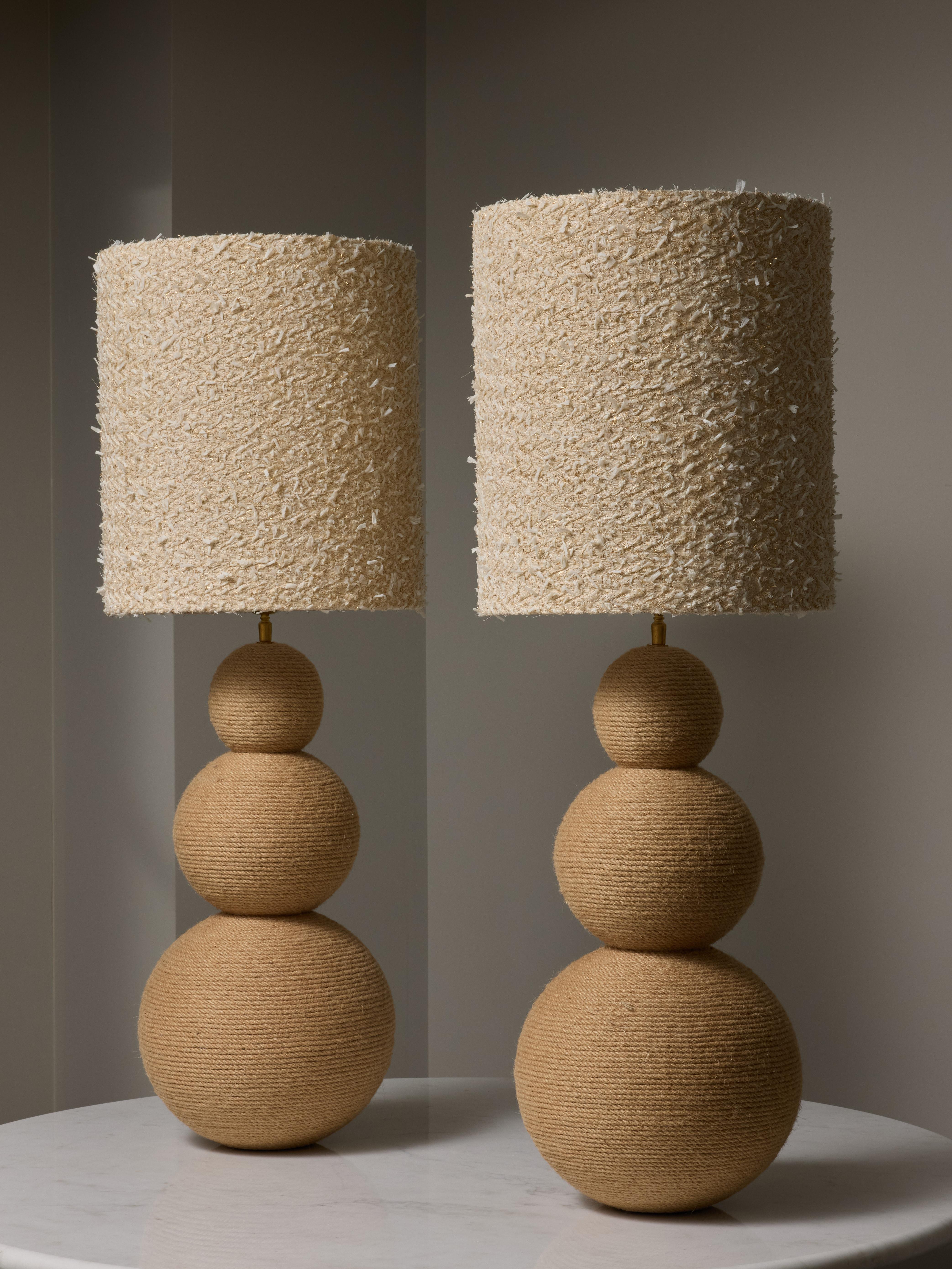 Pair of table lamps made of metal entirely wrapped by a tight rope circling around from the feet to the very top.

One source of light per lamp.

Dimensions with the shades: ø36 H102cm