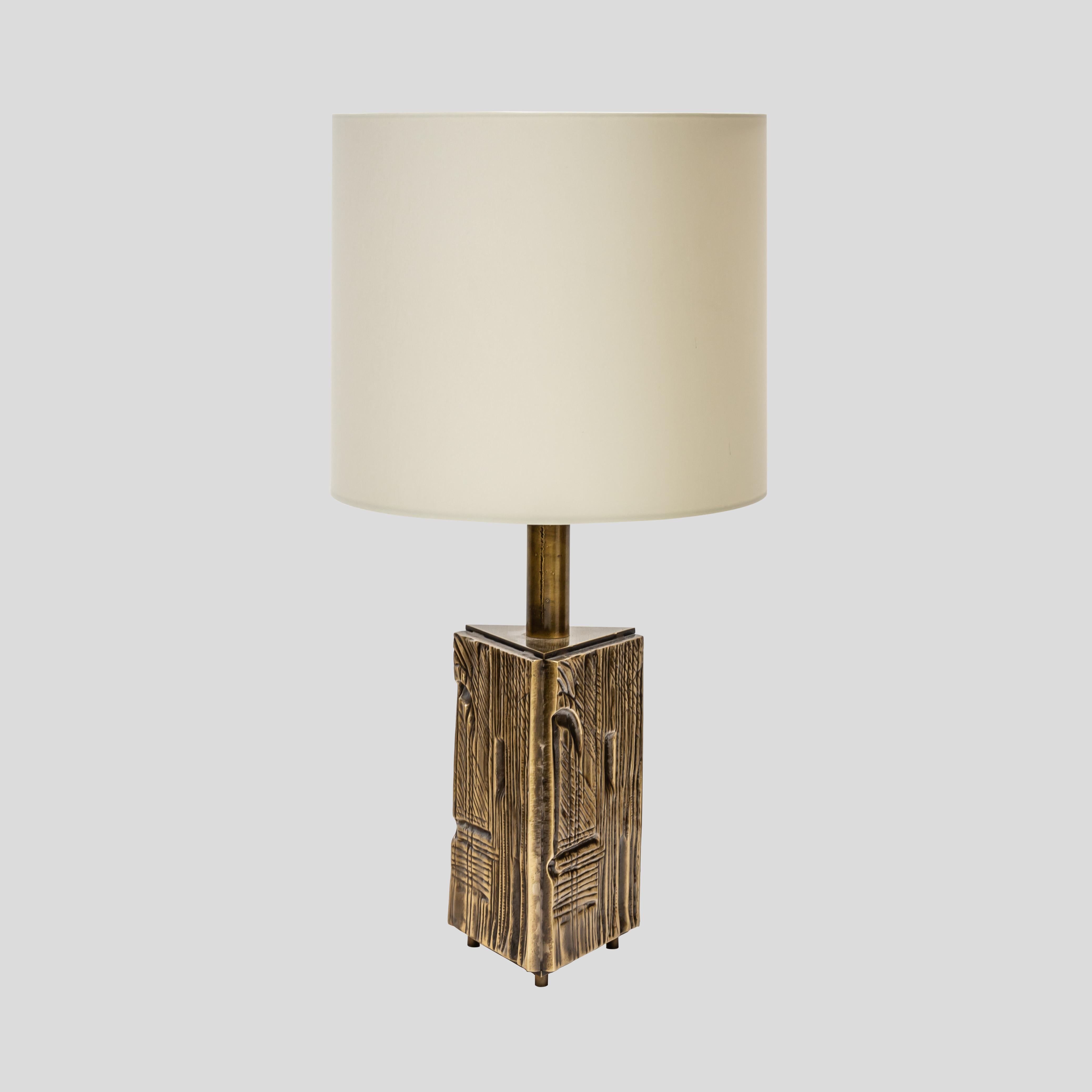 Triangular prism brass structure with the original patina, decorated with abstract motifs in a low relief technique on three feet.
This pair comes with cylindrical shaped cream white colour matt silk shades.
1960s Italian design by artist Luciano