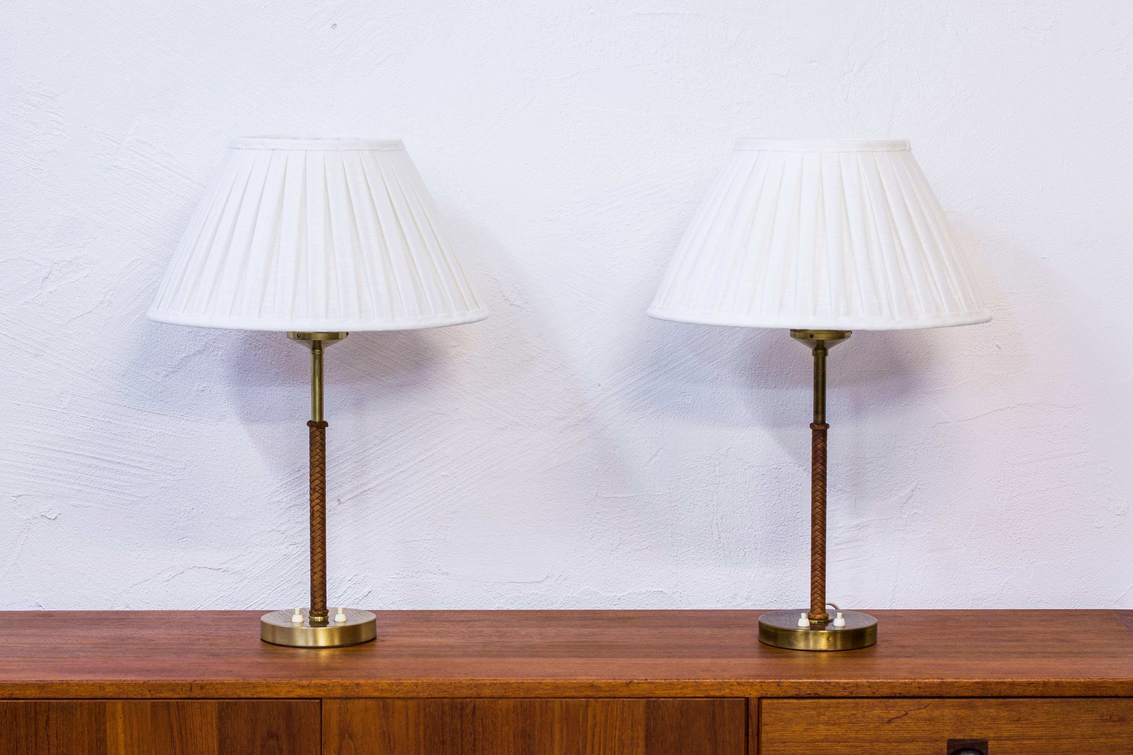 Pair of table lamps model 2043 designed by Åke Hultgren. Produced by Nordiska Kompaniet, NK in Sweden during the 1960s. Made from solid brass with original hand braided leather with patina. Dual light switch to adjust light in three stages, soft,