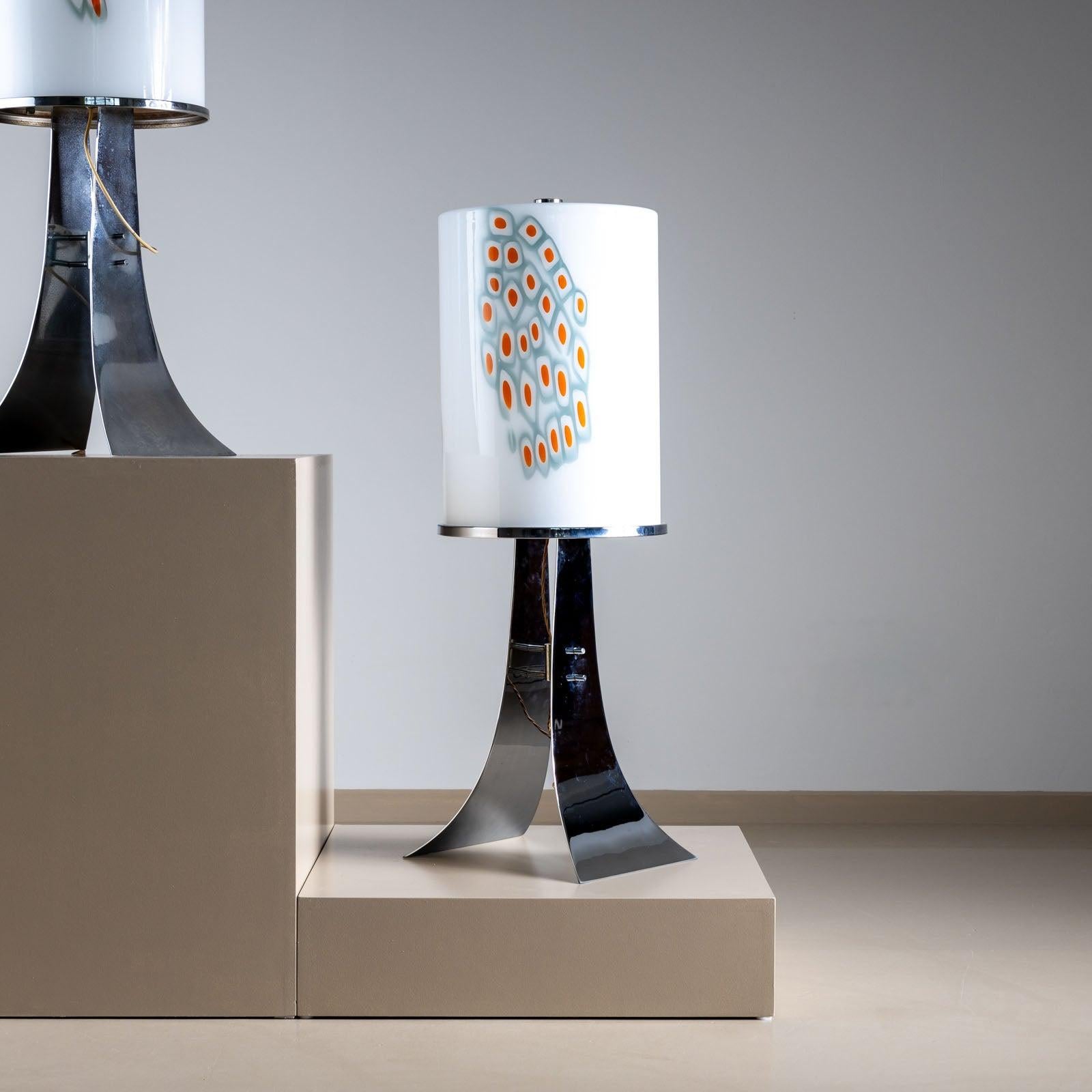 Pareja de grandes lámparas de sobremesa de Alfredo Barbini con base bifurcada cromada y pantalla cilíndrica de cristal de Murano opaco con inclusiones en forma de diamante en azul y naranja. 