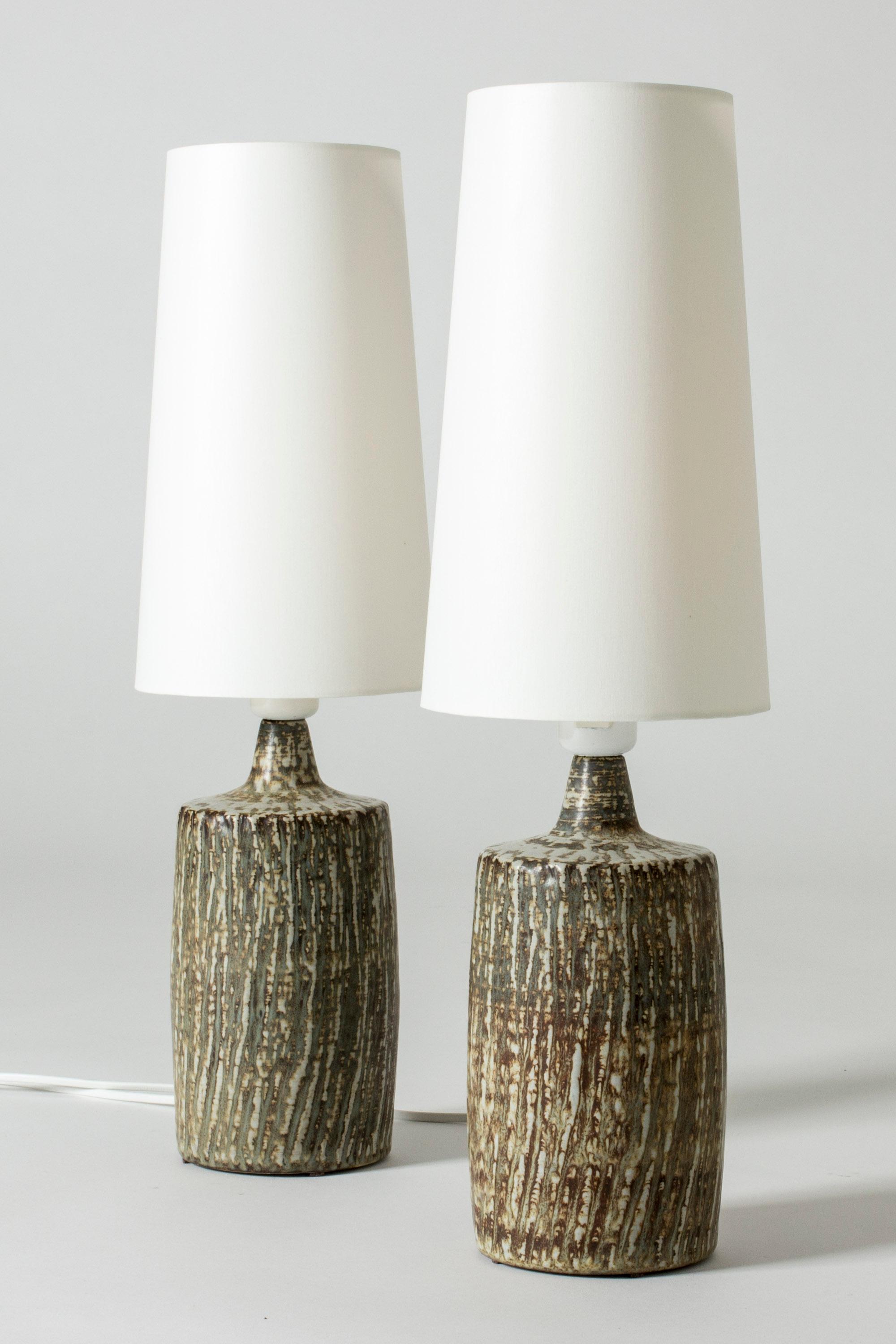 Pair of cool table lamps by Gunnar Nylund, with stoneware bases from the series “Sintra”. The series was introduced in 1965 and drew inspiration from Danish midcentury stoneware design. Rustic, organic look.