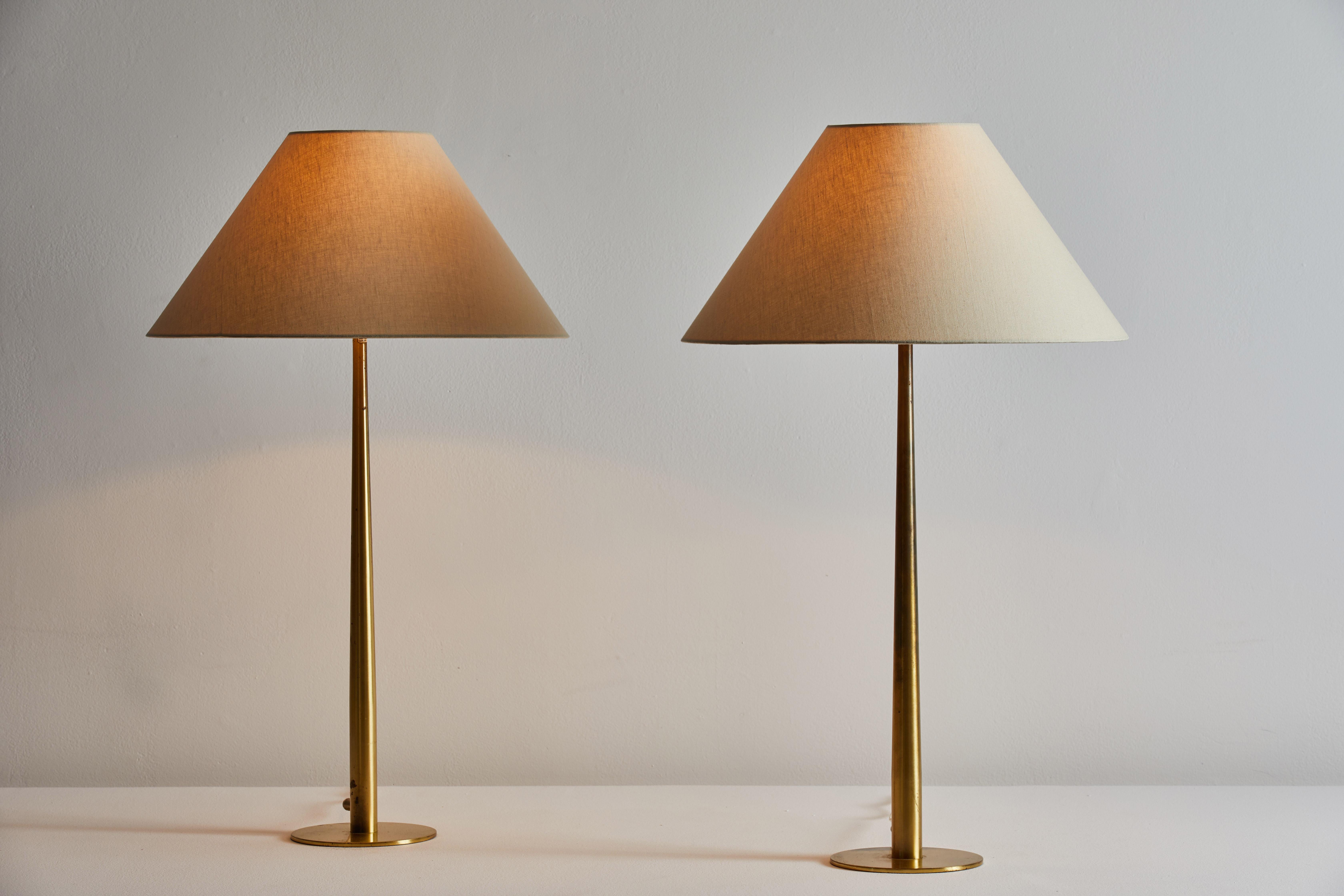 Pair of table lamps by Hans Agne Jakobsson. Designed in Sweden, circa 1960s. Brass stems with custom fabricated linen shades. Original cords. Each light takes one E27 75w maximum bulb. Bulbs provided as a onetime courtesy. Retains original
