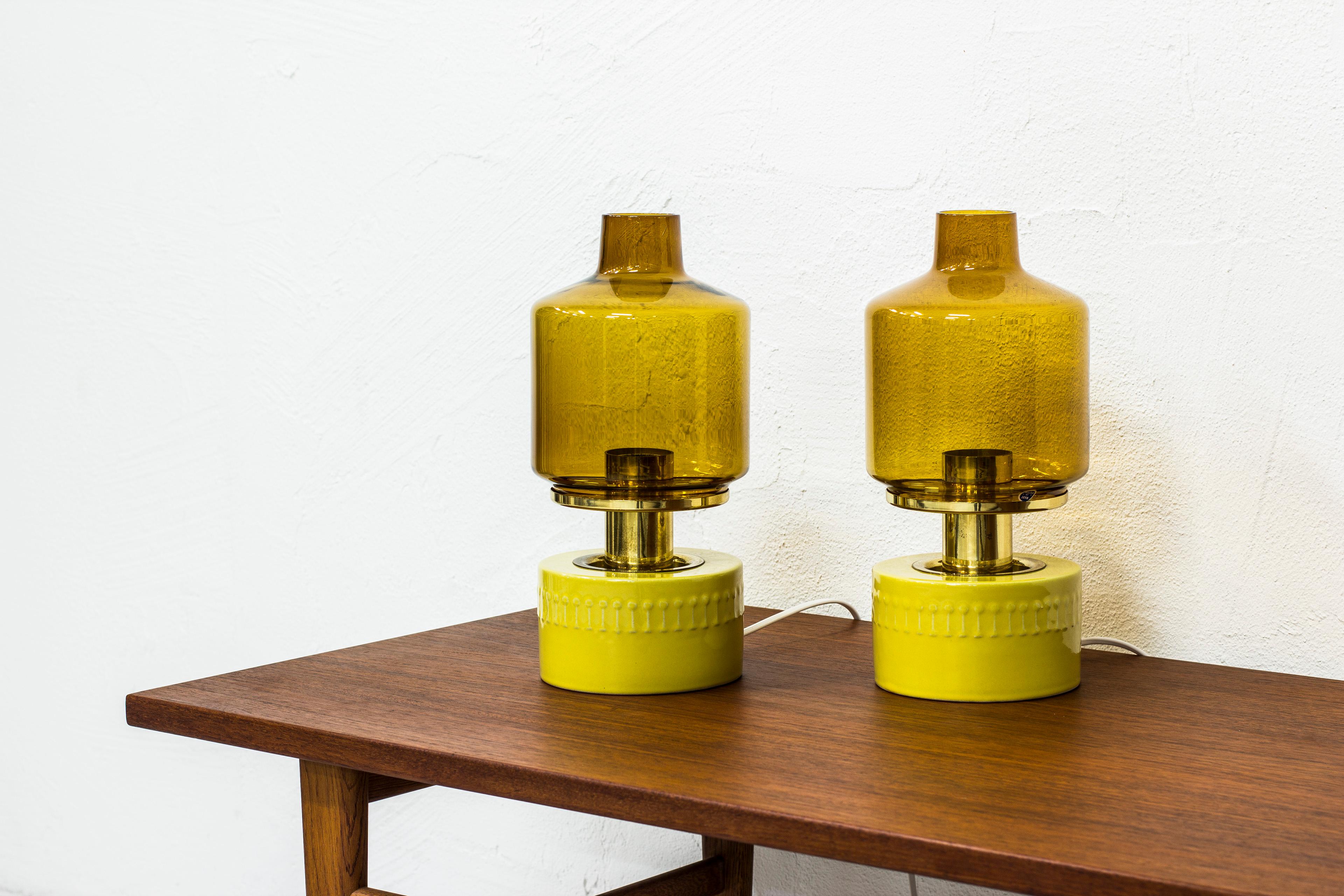 Rare pair of table lamps designed by Hans Agne Jakobsson. Produced by his own company in Markaryd. Made from brass, glass and stoneware. The ceramic part was made on commission by Höganäs Keramik. Light switch on the chord. Excellent vintage