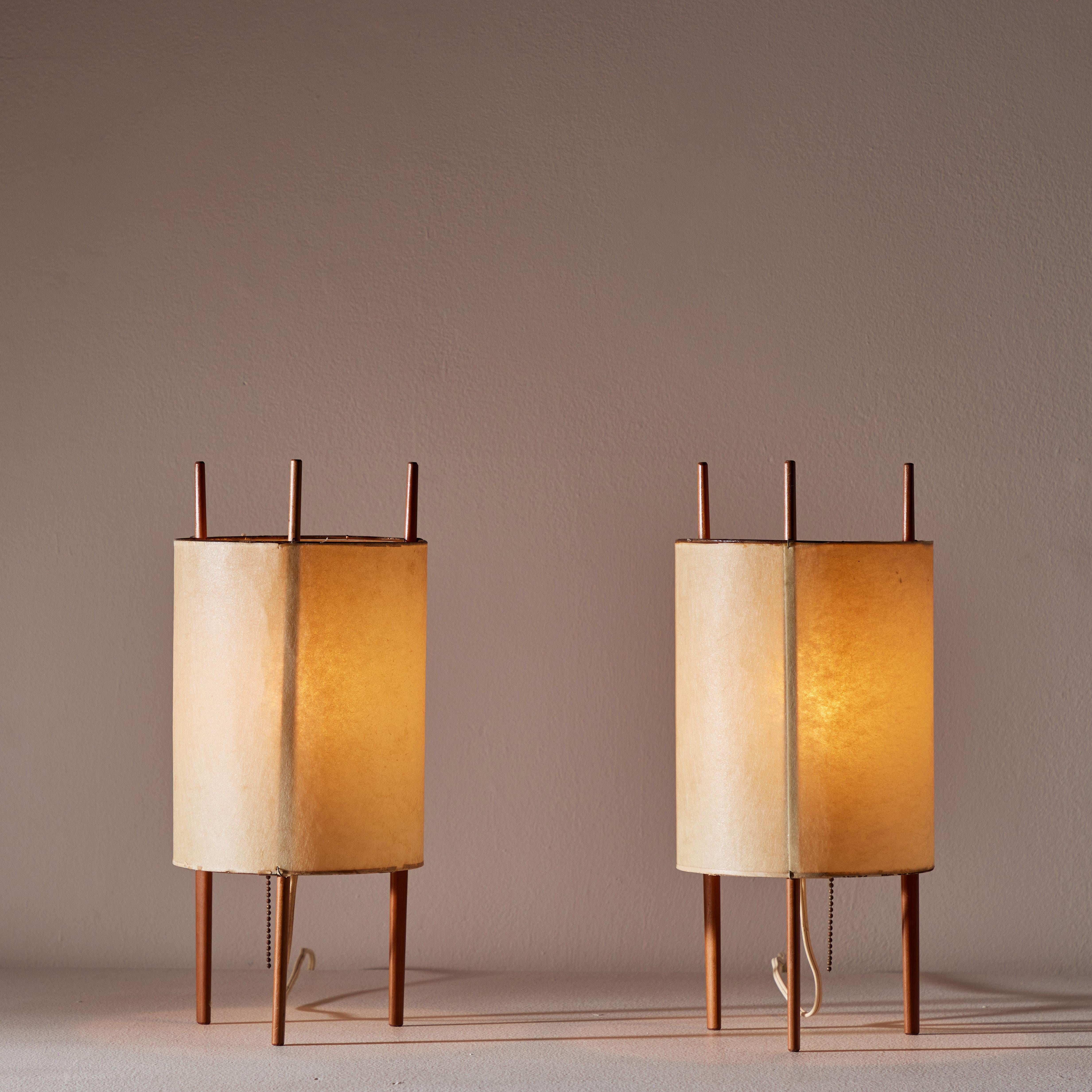 Pair of table lamps by Isamu Noguchi for Knoll. Manufactured in U.S. circa early 1950's. Parchment paper shade, cherrywood frame. Original cord that works with U.S. sockets. We recommend one E27 60w maximum bulb per fixture. Bulbs provided as a one