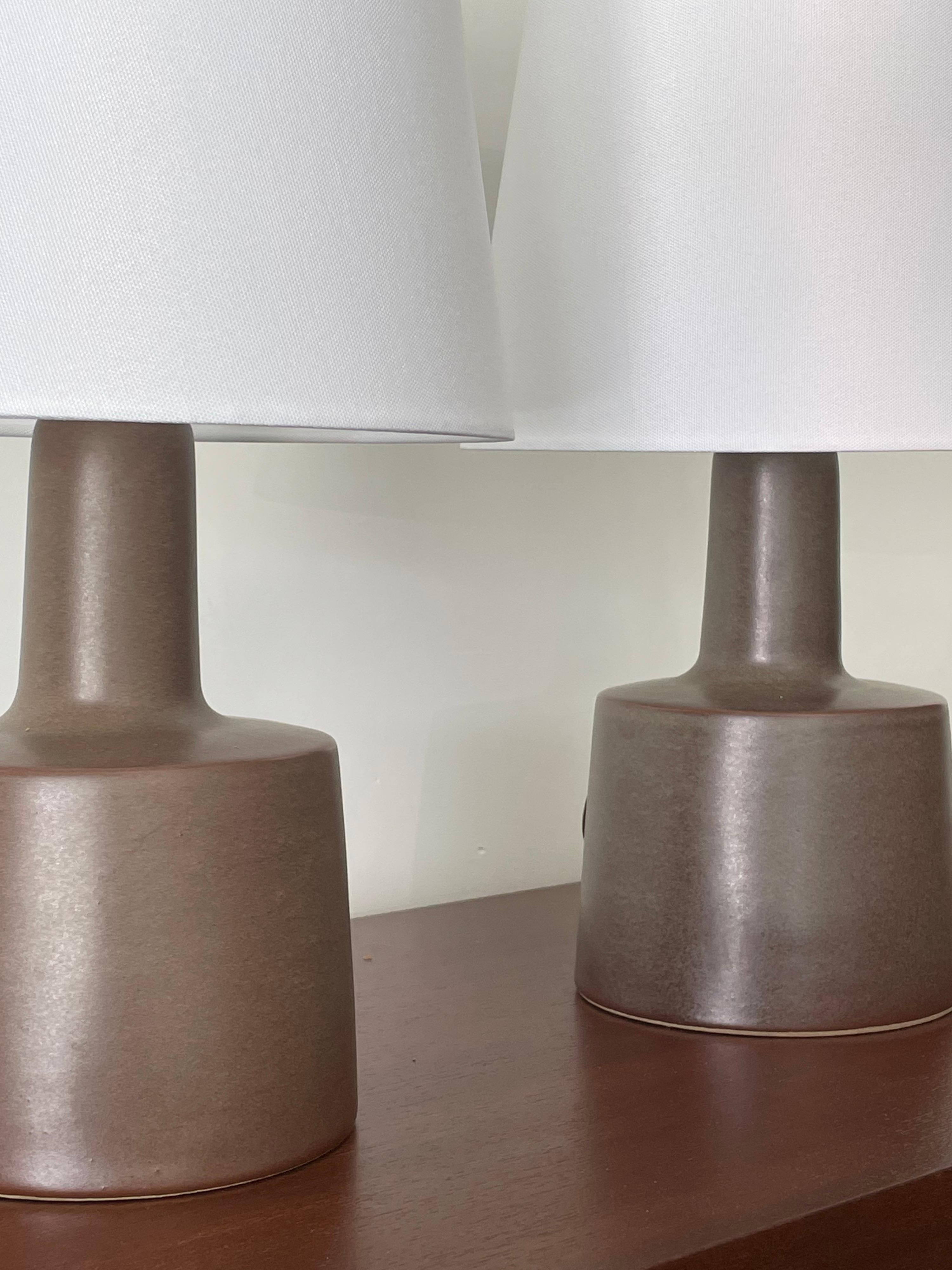 Pair of table lamps designed by ceramicist duo Jane and Gordon Martz for Marshall Studios. Color is brown with a green hue. 

Overall dimensions: 
15.5” tall 
10” wide 

Ceramic portion only 
9” tall 
6” across.