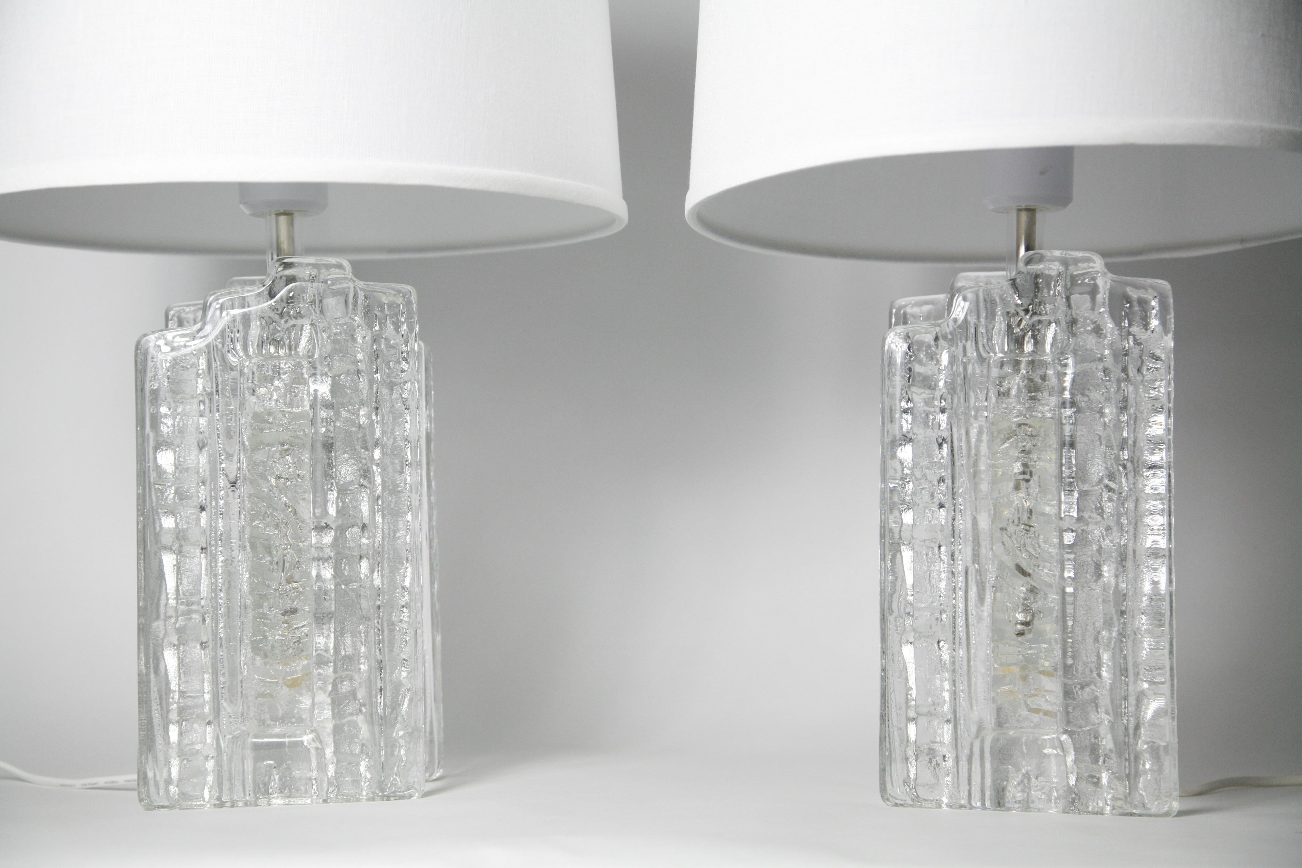 Paire de lampes à bloc en cristal duo épais avec un motif à l'intérieur du verre ; la surface extérieure est lisse, à l'exception de la section centrale qui présente un motif qui semble presque givré, Suède, années 1970. Peut être recâblé sur