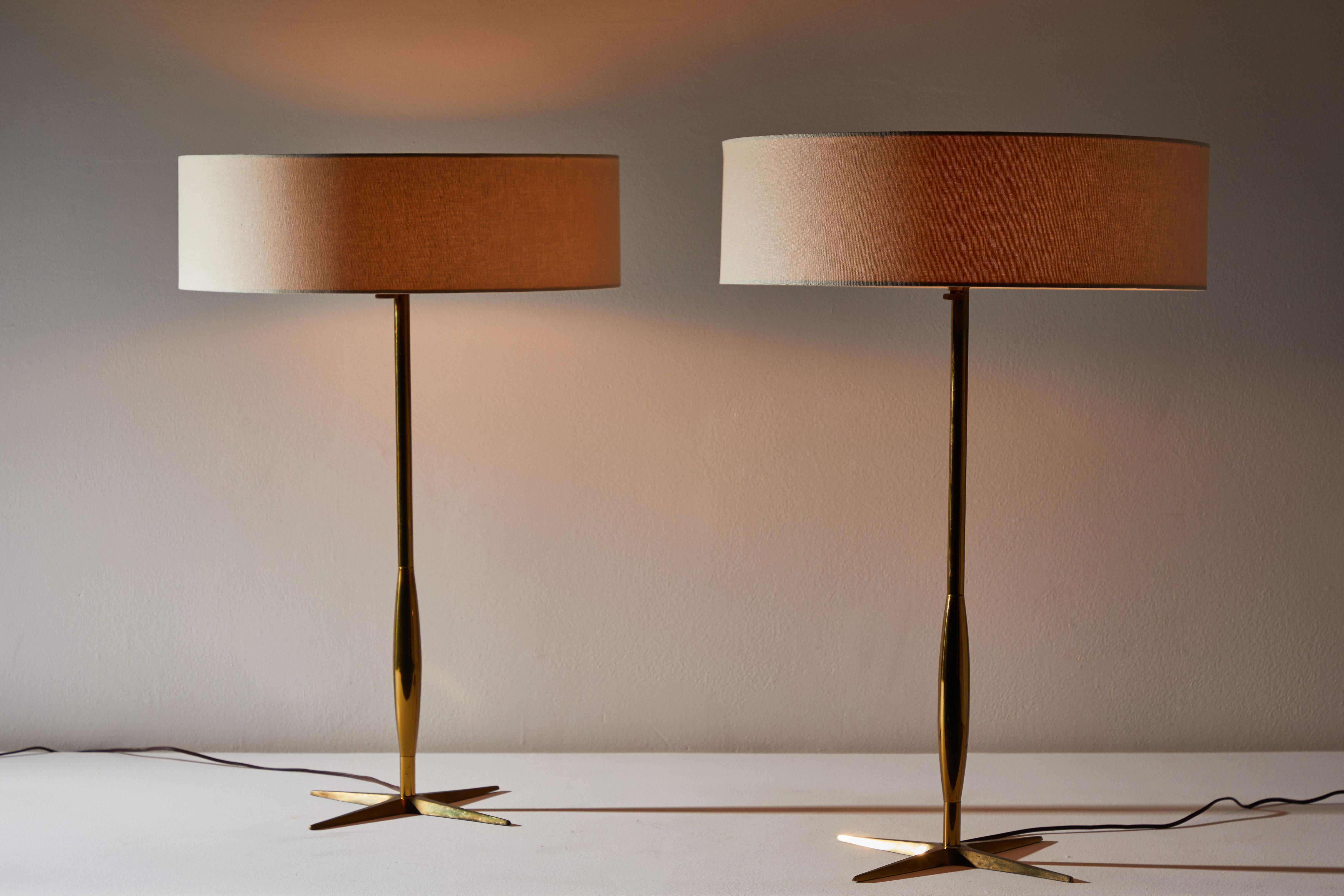 Pair of table lamps by Stiffel. Manufactured in the USA, circa 1950s. Brass base and stems. Custom linen shades. Original cords. Each light takes three E26 25W maximum bulbs.
   