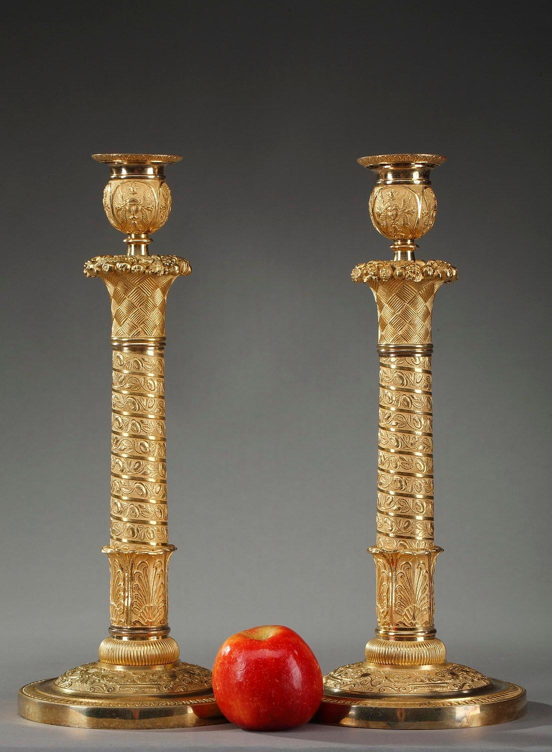 Pair of Restauration gilt bronze table lamps, the stem finely chiseled with a continuous helical frieze winding from the base to the capital, and decorated with floral motif. The design of the stem was inspired by Trajan's column built between 107