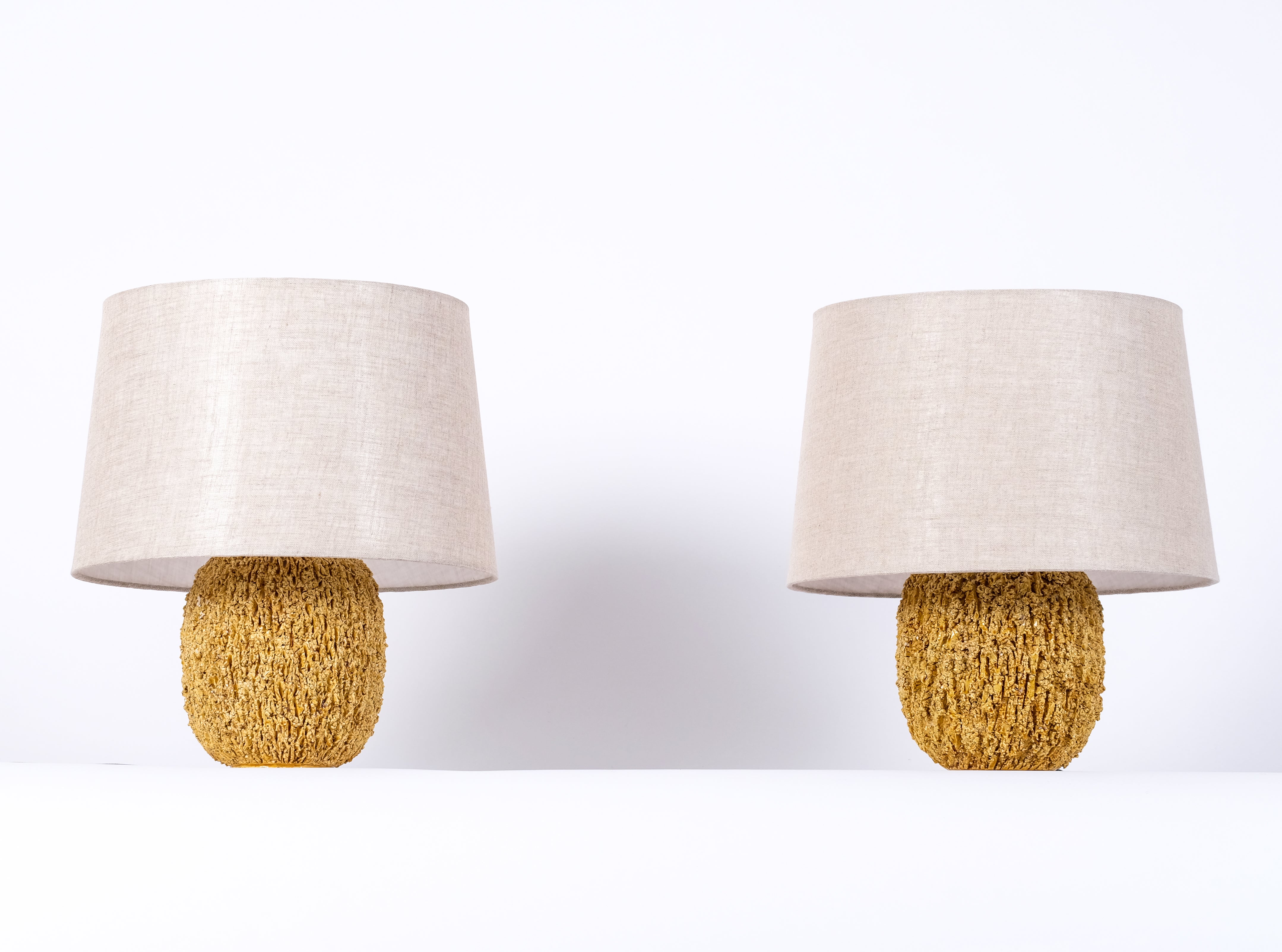 Pair of ceramic table lamps in bulbous shape by Gunnar Nylund, composed of chamotte clay and glazed with a white colored luster glaze. Produced by Rörstrand. Stamped.