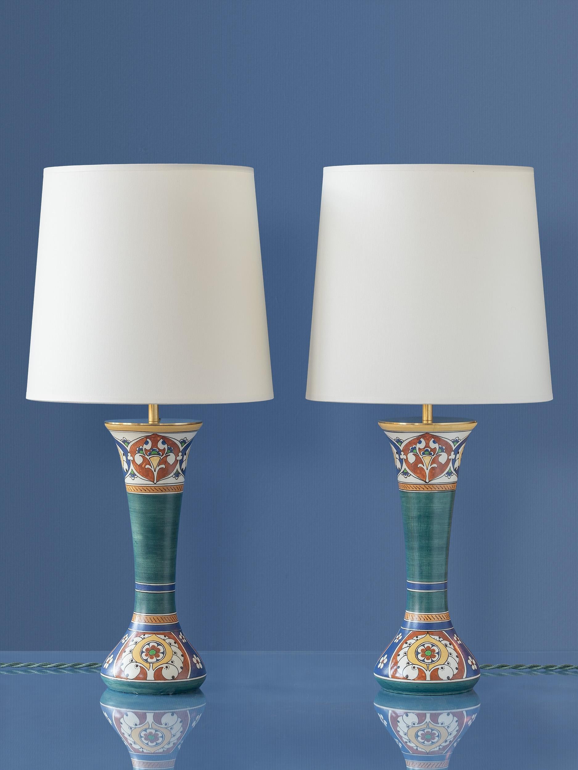 Meet Toni & Tini! This one-of-a-kind pair of lamps are lovingly handcrafted from antique, rare vases from the renowned Arnhemsche Fayencefabriek. Each vase, forming the lamp's base, is a testament to the superb artistry of the past, featuring