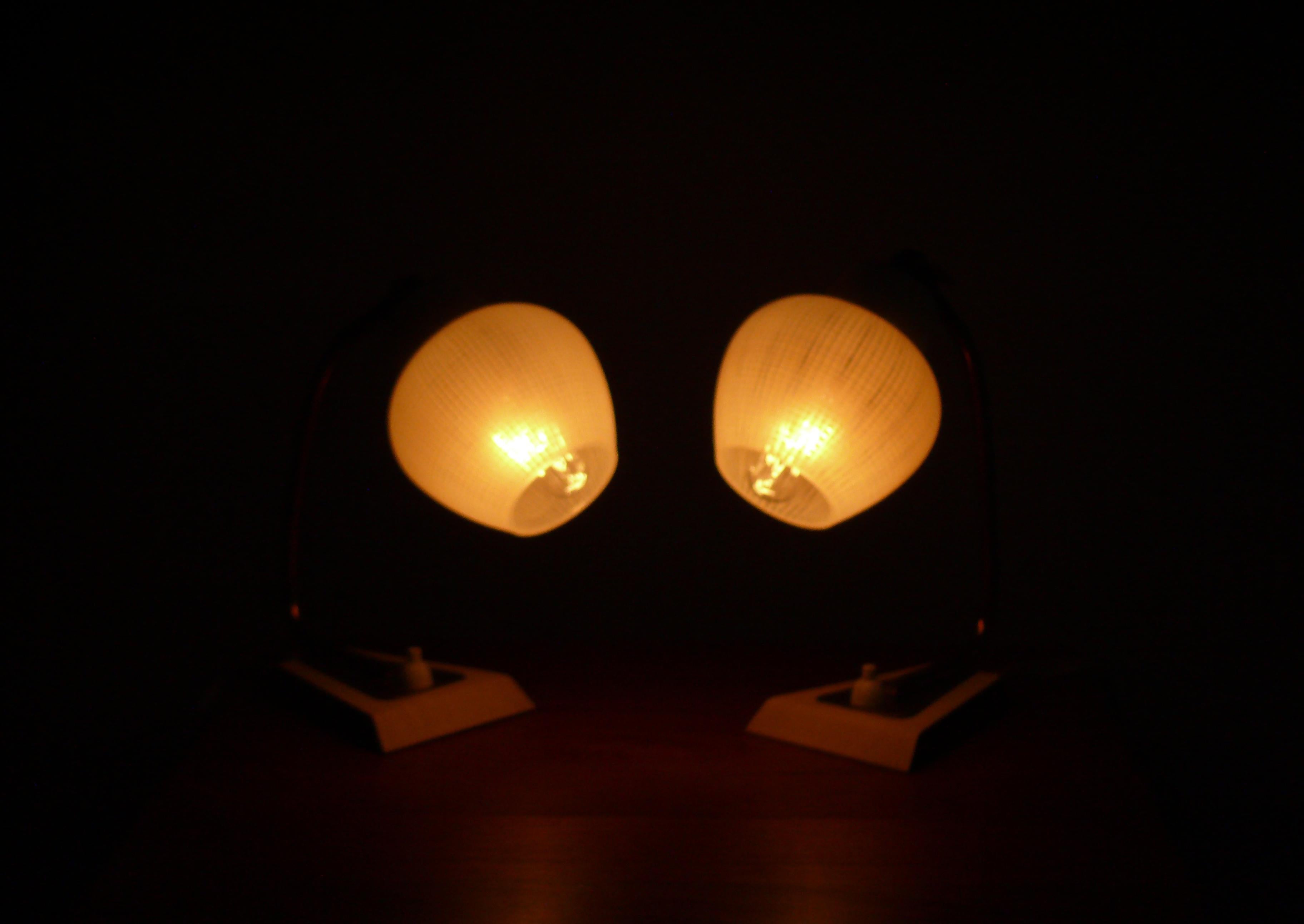 1 Paar Tischlampen aus den 1960er Jahren mit Opalglasschirmen. Die Lampen haben einen Sockel aus lackiertem Metall mit einer Messingauflage, einen Messingarm und einen Glashalter aus lackiertem Metall. Die bemalten Flächen sind mit einem beigen
