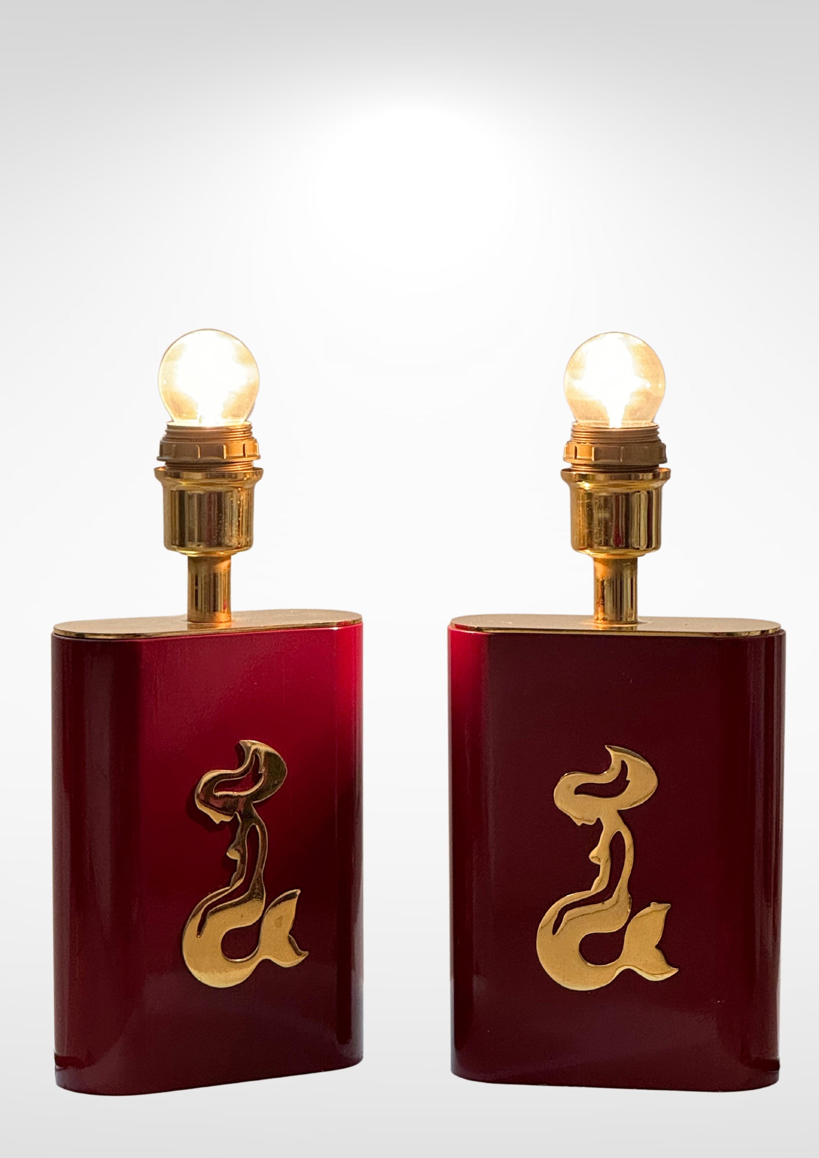Set di 2 lampade da tavolo di produzione belga degli anni '70 circa.
Coppia di lampade molto decorative, in legno laccato rosso bordeaux.
Ogni lampada è impreziosita da una placca in ottone massiccio raffigurante una sirena inginocchiata.
Di