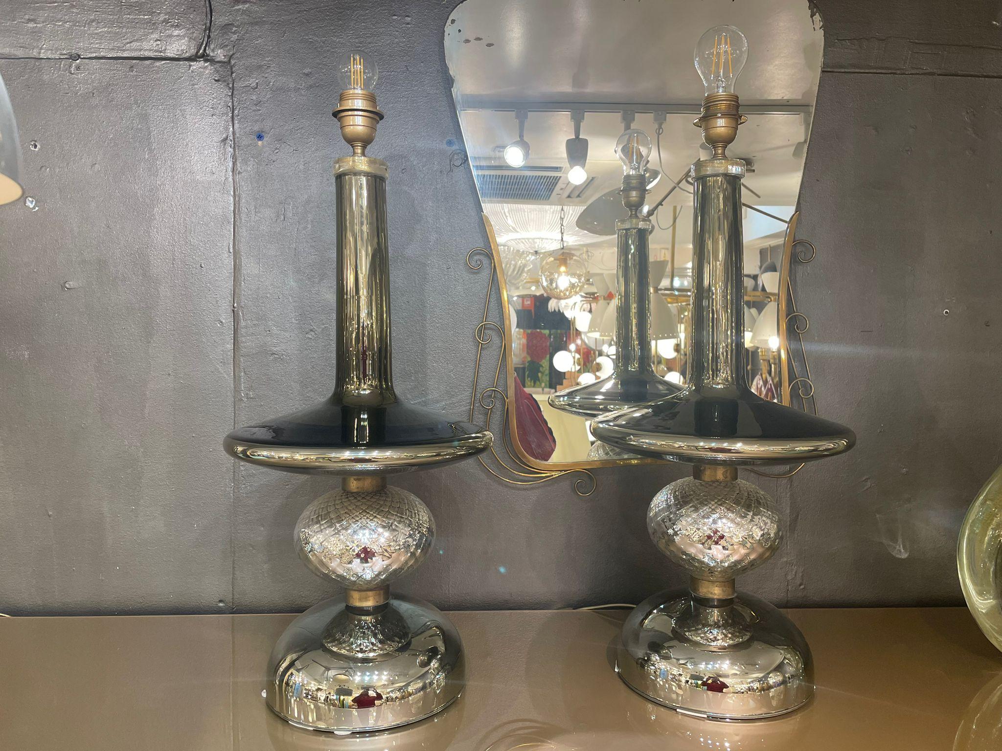 A pair of table lamps in silver mirrored glass in three sections separated by glass rings. 