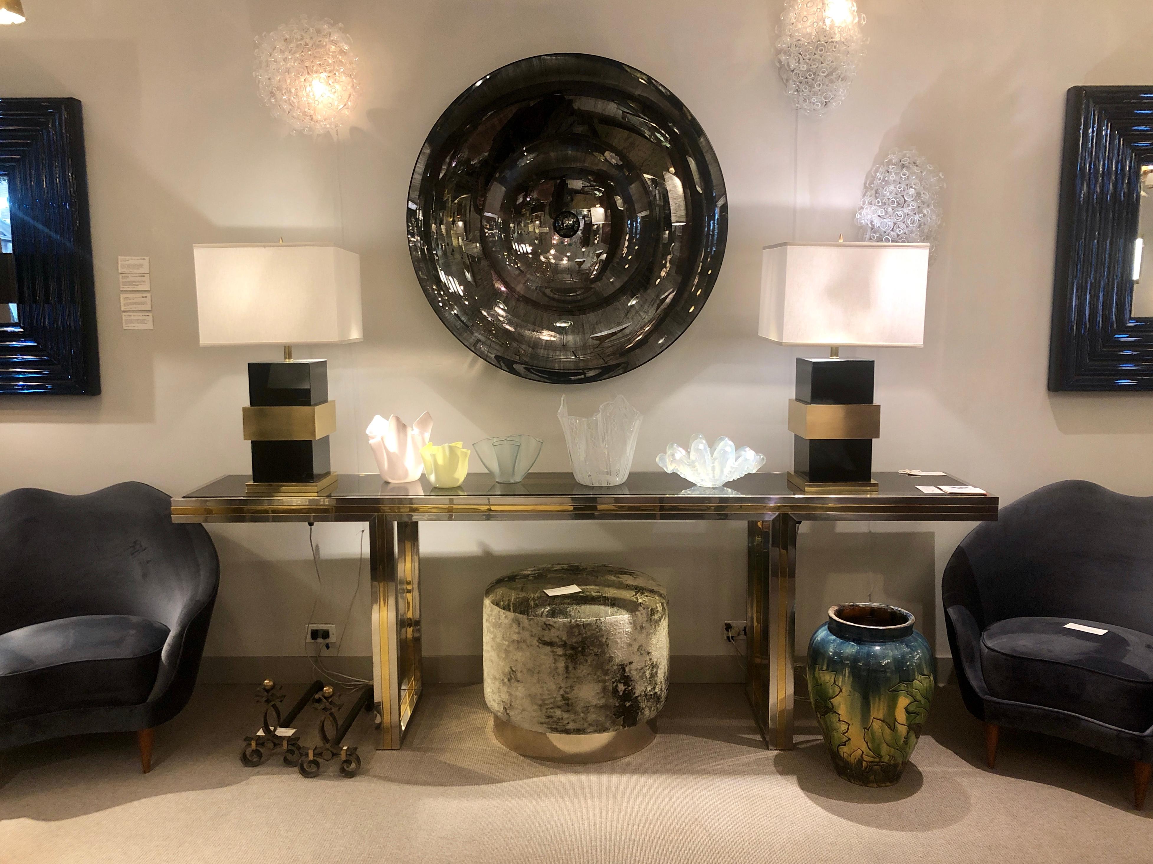 Black plexiglass bodies, each holding a broad brass band in its middle, raised on a square brass base.

(Lamp shade not included)