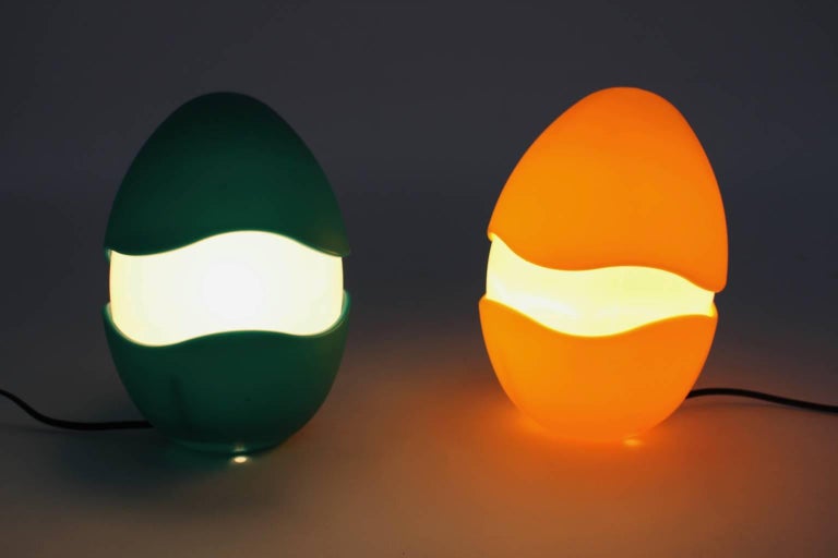 A pair of space age plastic table lamps, which are shaped like eggs in the colors green, yellow and white.
The designer of these table lamps, named 