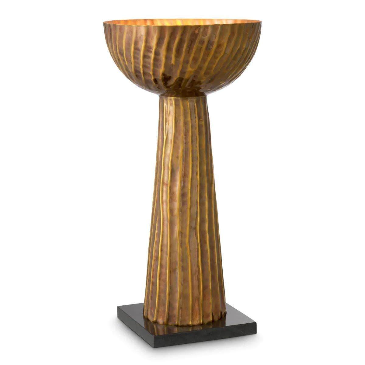 Entirely handmade from patinated brass, this lamp features an elegant, structured base that highlights its sophisticated design. The patinated brass gives it a timeless elegance, making it an ideal decorative piece for your living room, bedroom or