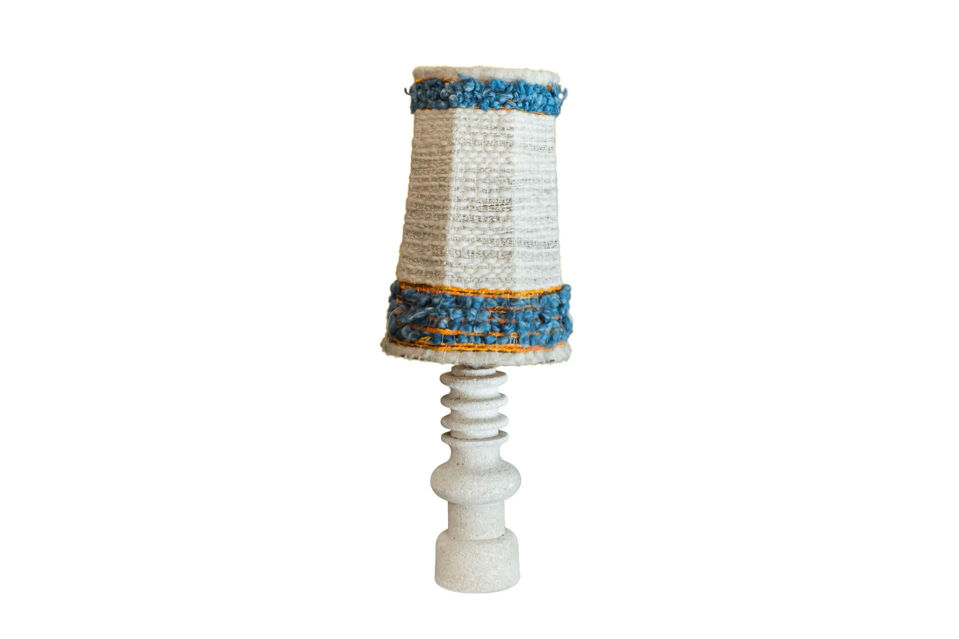 Pair of table lamps,
Stone decorated with rings, 
Woolen lampshades, 
circa 1950, France. 

Measures: Diameter 39 cm, height 95 cm.