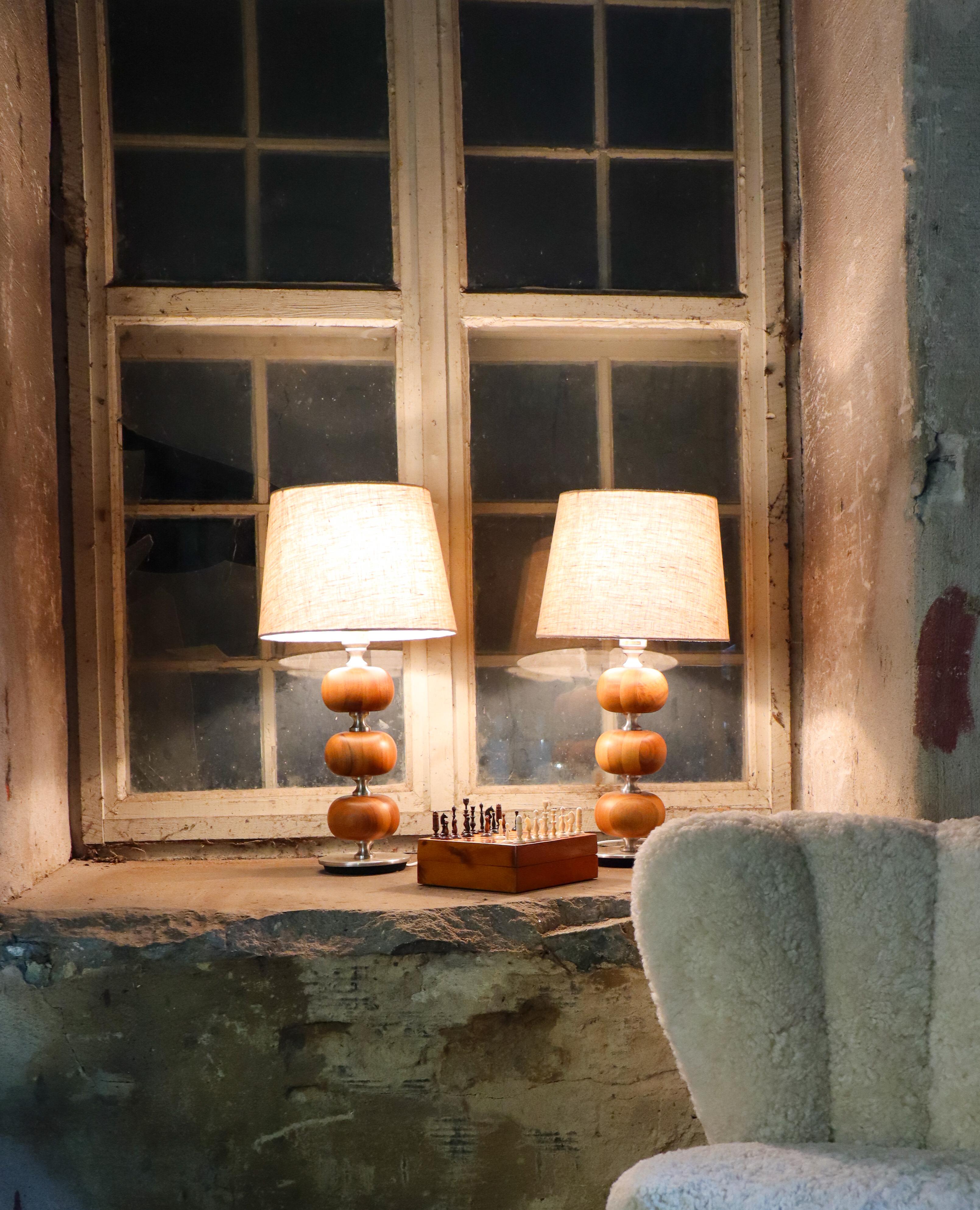 Un par de lámparas de sobremesa de nogal y metal diseñadas por Henrik Blomqvist en Tranås Stilarmatur AB, Suecia, en la década de 1960. Sin contar las pantallas, miden 40 cm de alto y unos 15 cm de diámetro. Ambos están en excelentes condiciones.