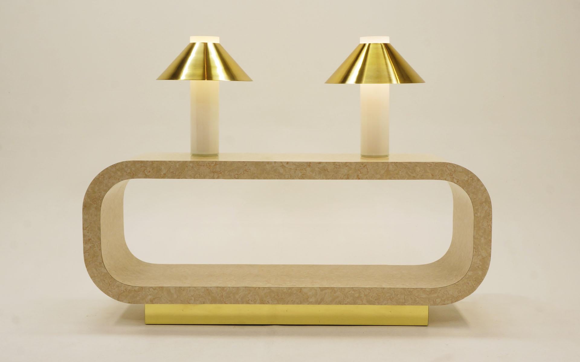 Pair of 1970s table lamps featuring white blown glass tubes housing the lamp stem and light with brass shades that ingeniously slip over the top of the base. The photos may look somewhat yellow, but the glass is white in person. We don't know the