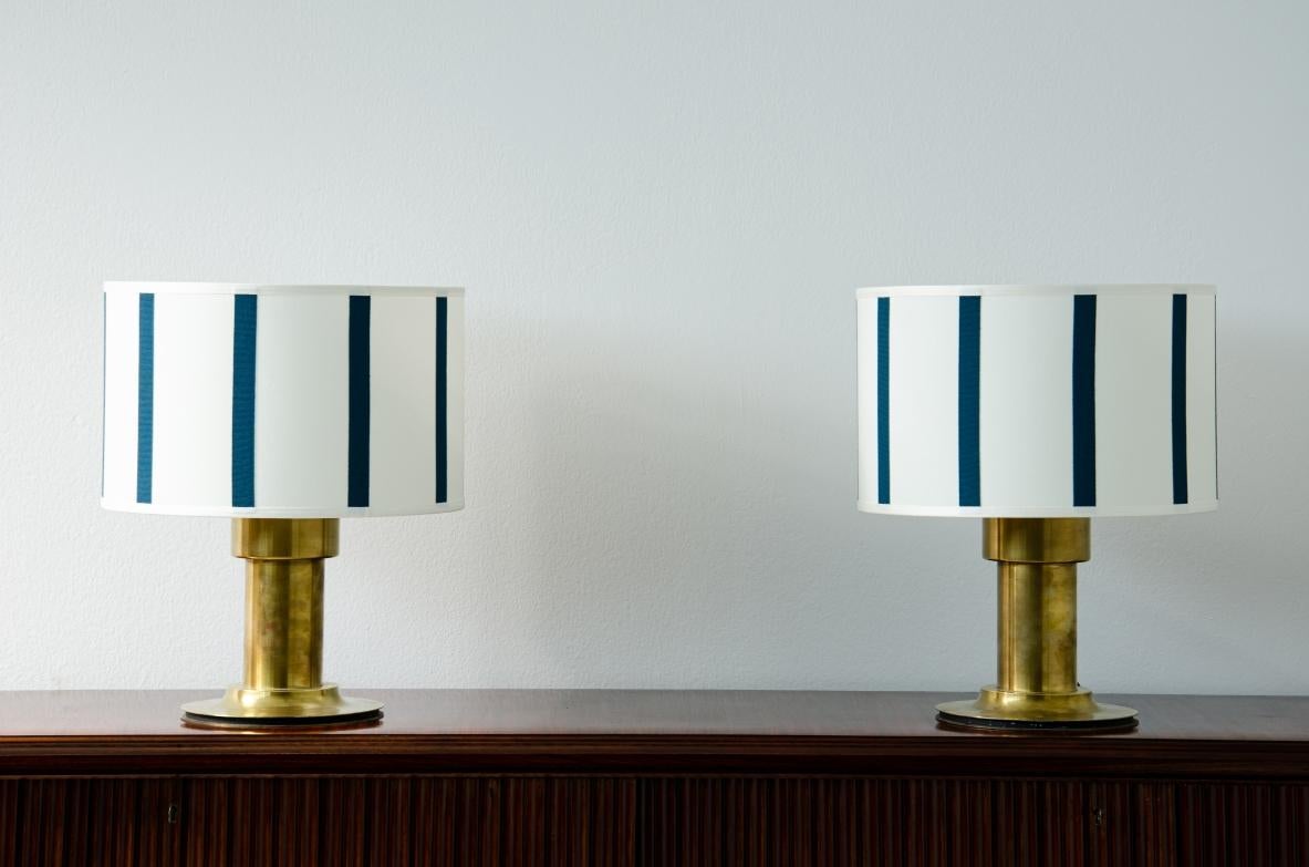 Pair of table lamps with a strong brass cylinder stem and top in ivory fabric with petrol green stripes.

1970's Italian manufacture.

