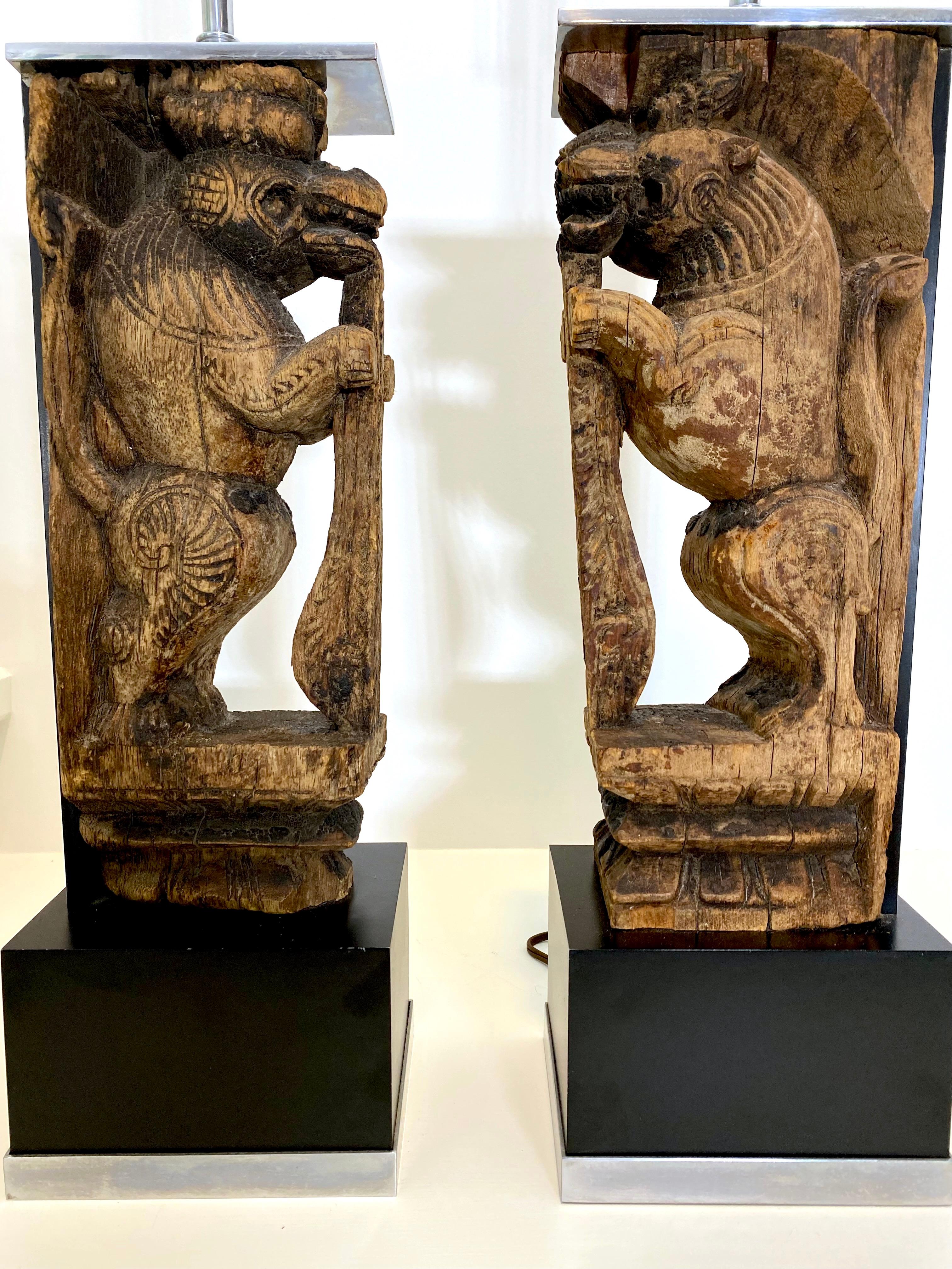 Fantastique paire de sculptures antiques de lions de temple sculptées à la main qui ont été montées en Nickel comme lampes de table dans les années 60, ce qui leur donne à la fois un aspect midcentury et antique. D'une maison unique à Cambridge,