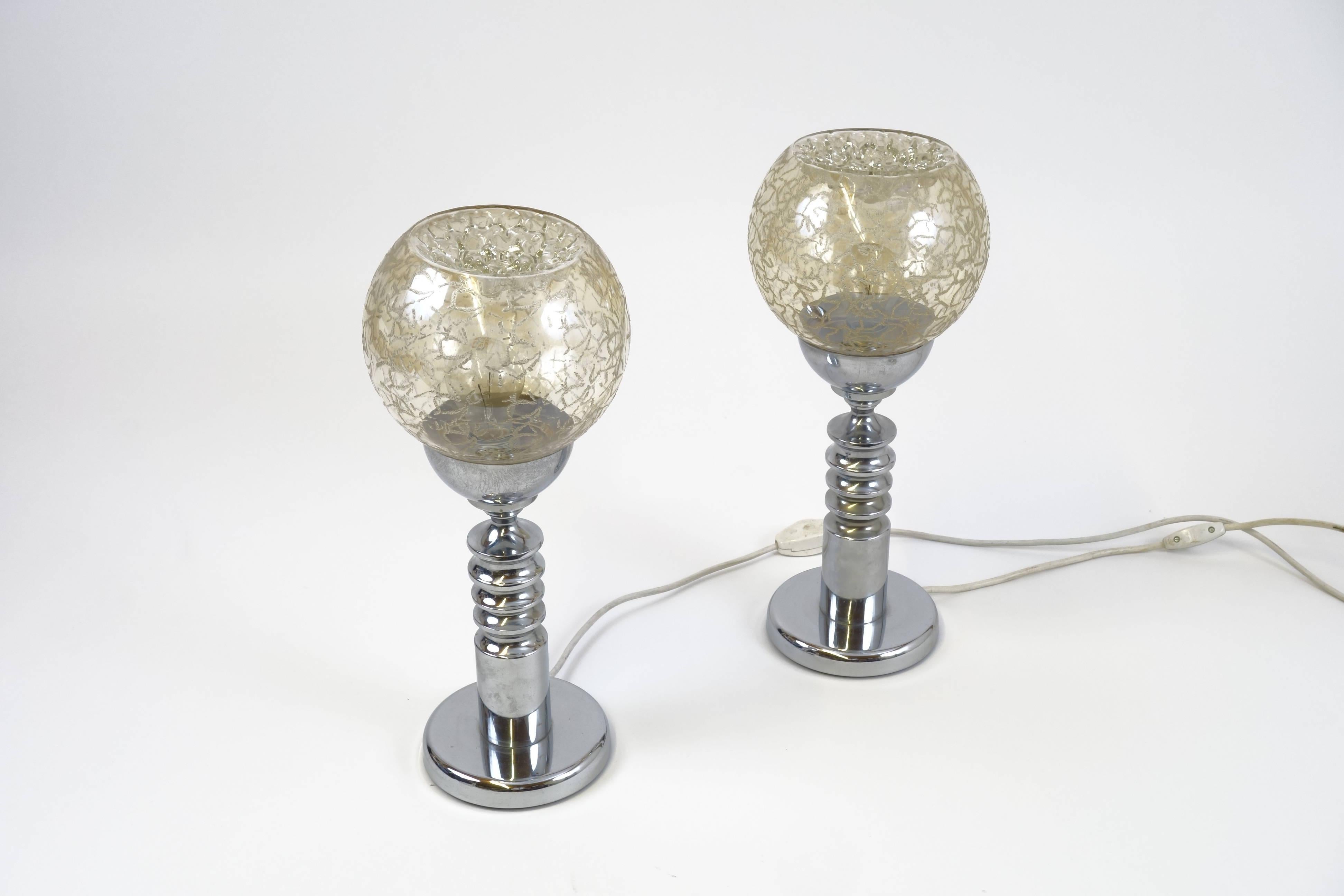 A pair of table lamps with chromed metal shafts and structured glass hemispheres, most probably manufactured by Barovier & Toso during the 1970s. Engraved Murano glass hemispheres, appearing in warm a yellow hue, offering an attractive contrast to