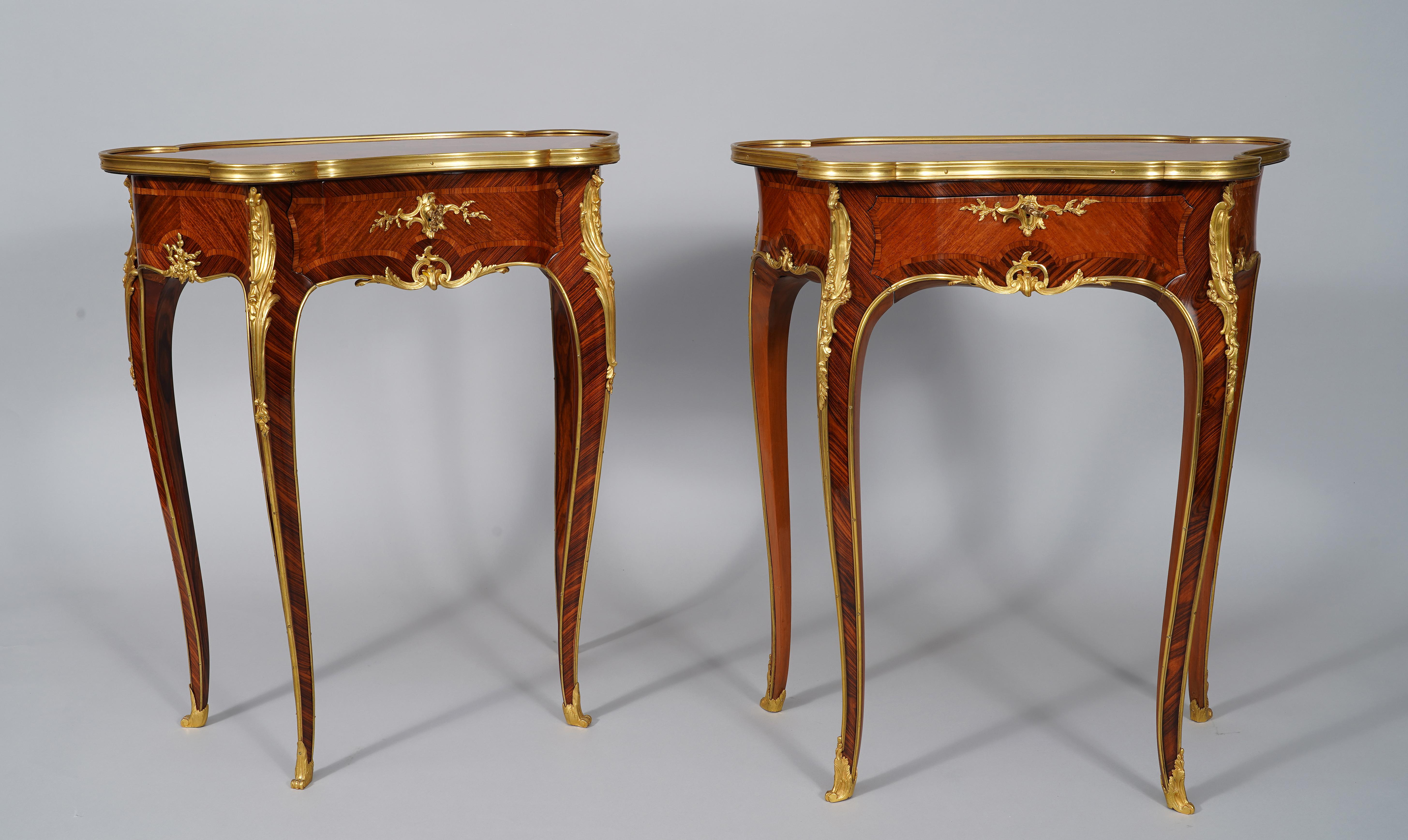 Charming Louis XV style tables forming a pair, in a scalloped shape, opening with a drawer on the belt and made in wood veneer. Their tray surrounded by a bronze mold is decorated with elegant floral marquetry in 