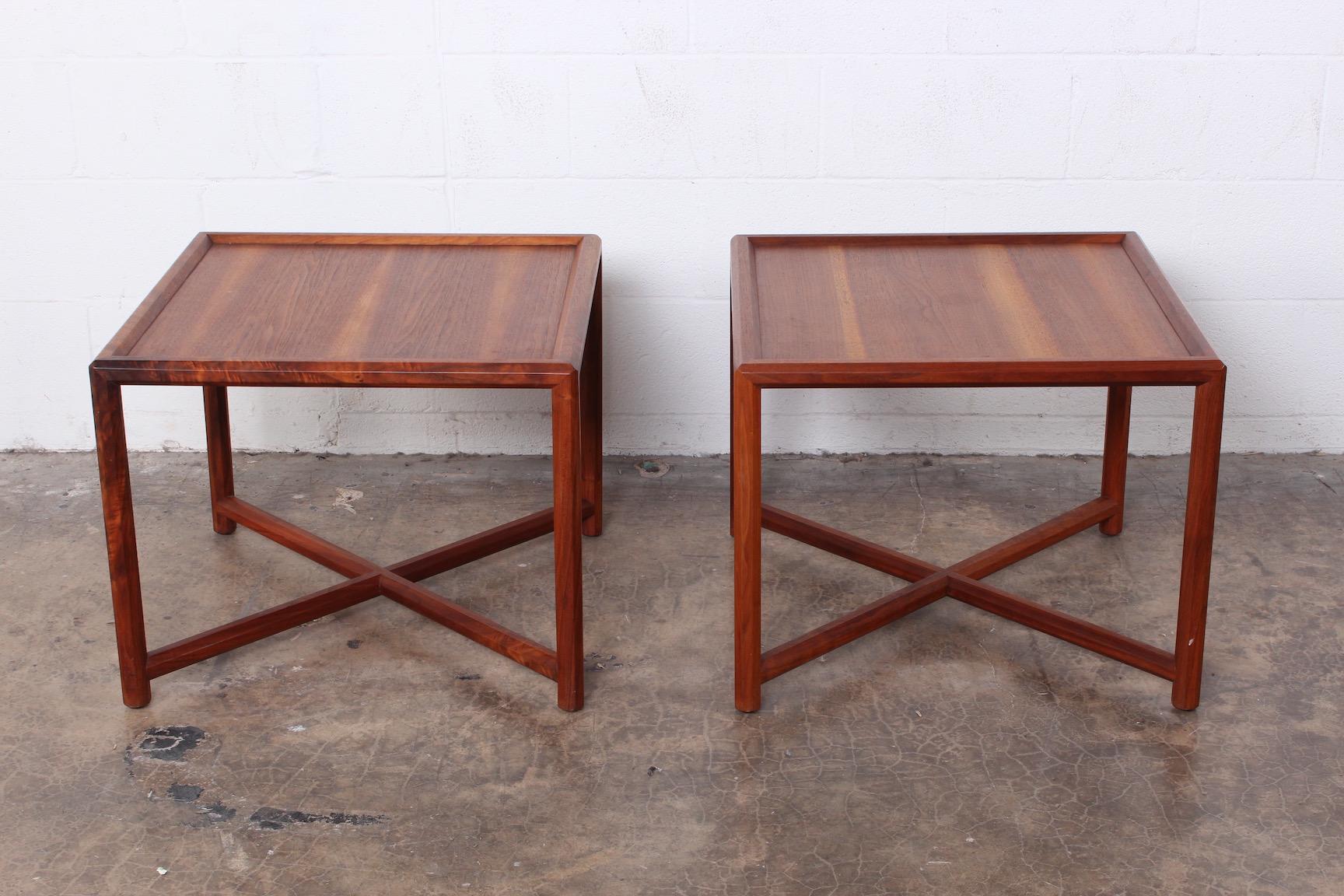 A pair of walnut Janus end tables designed by Edward Wormley for Dunbar.