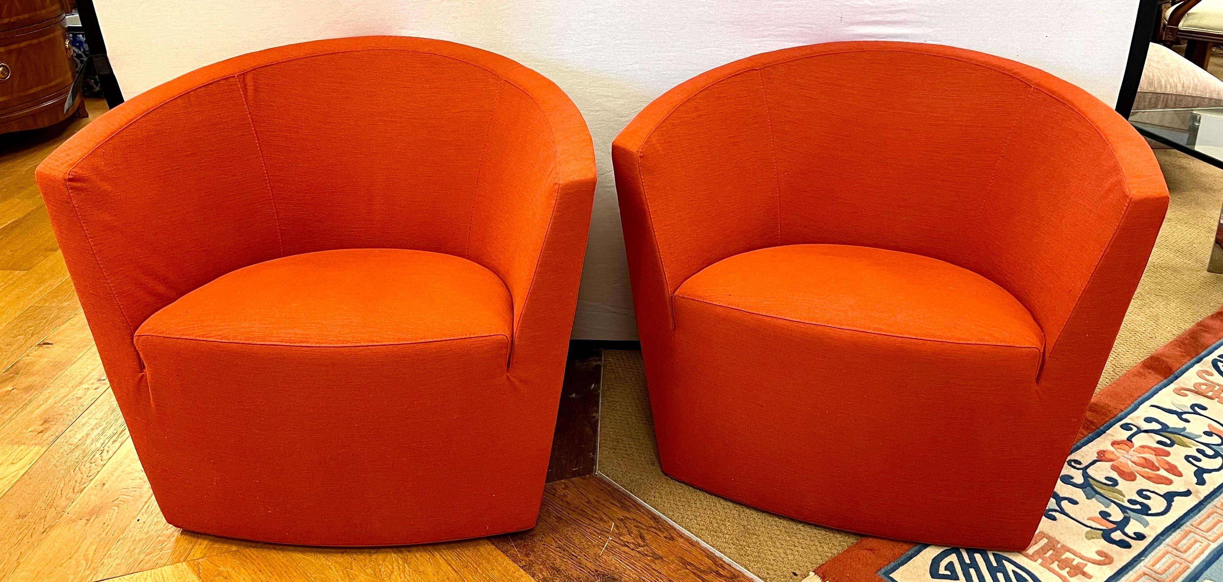 Pair of Tacchini streamlined swivel chairs boasts a barrel silhouette and is a versatile addition to your space. Upholstered in an orange linen fabric.
Made in Italy.