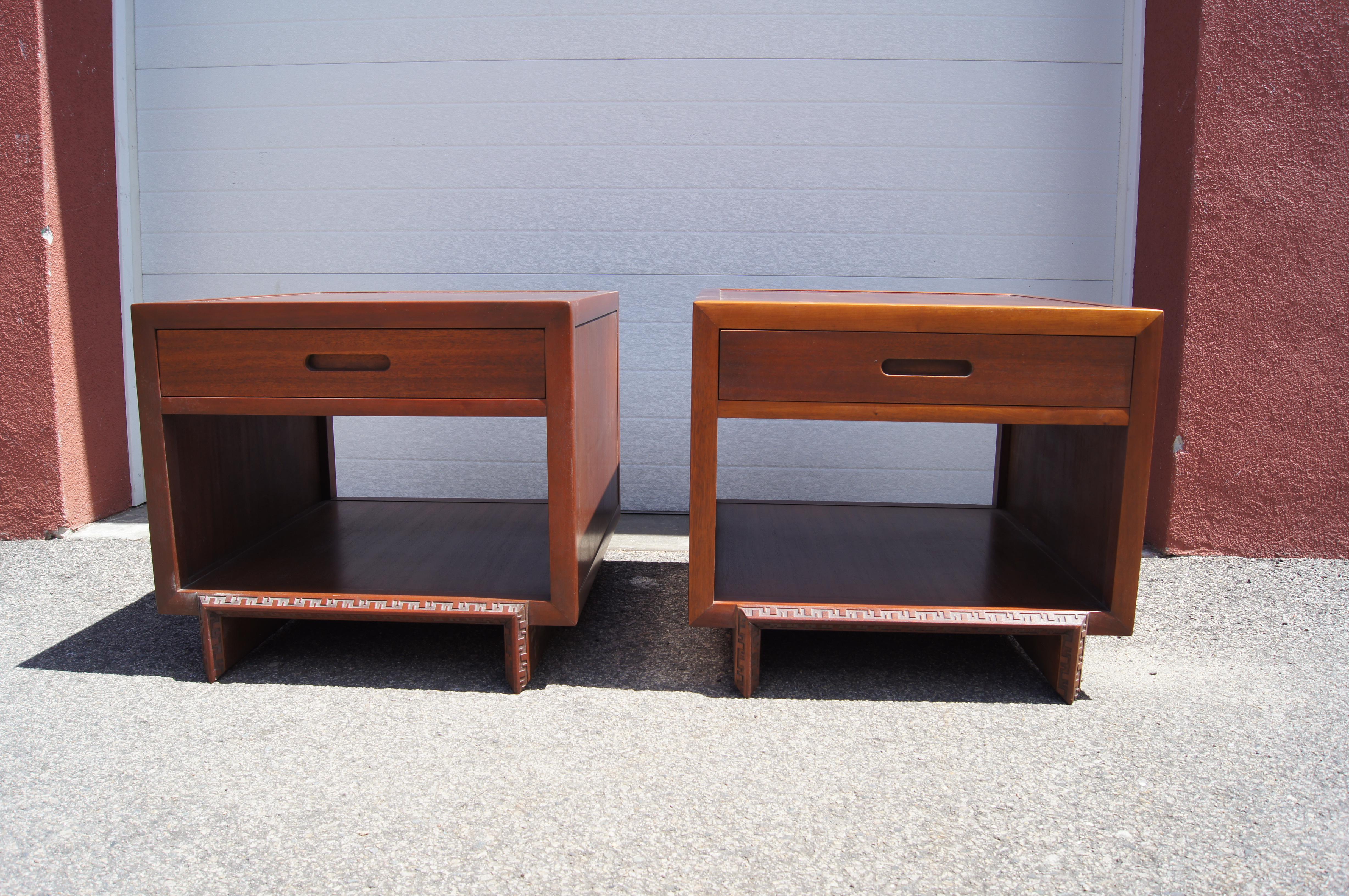 Frank Lloyd Wright designed these substantial mahogany nightstands in 1955 as part of his Taliesin collection for Heritage-Henredon, which manufactured them for two years only. With one drawer above open shelving, they are finished front and back