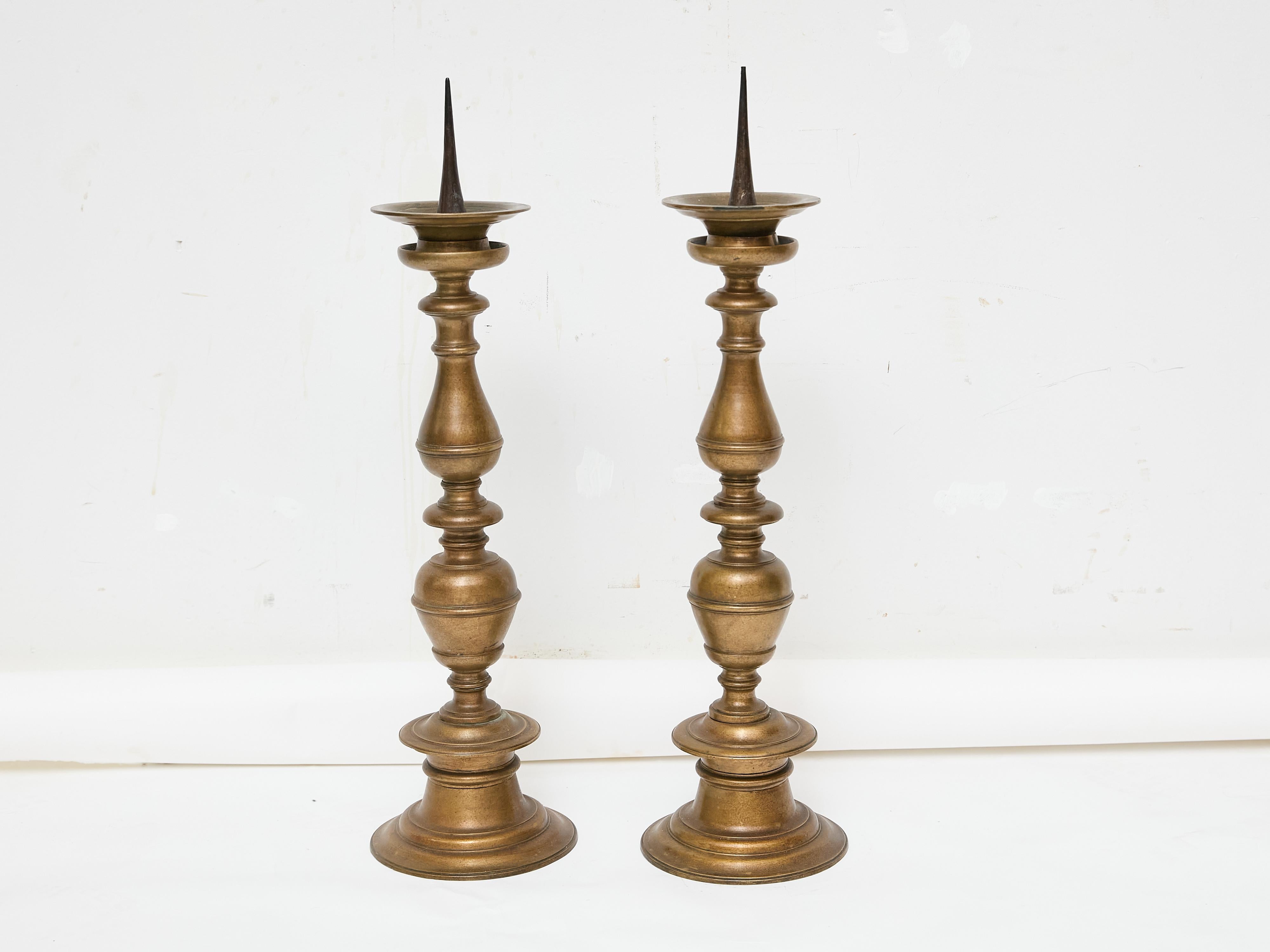 A tall and commanding pair of Italian pricket sticks in solid bronze, 18th century. At over 30 inches high, these were originally designed to hold substantial devotional candles, but their presence now feels almost sculptural—pure silhouette,
