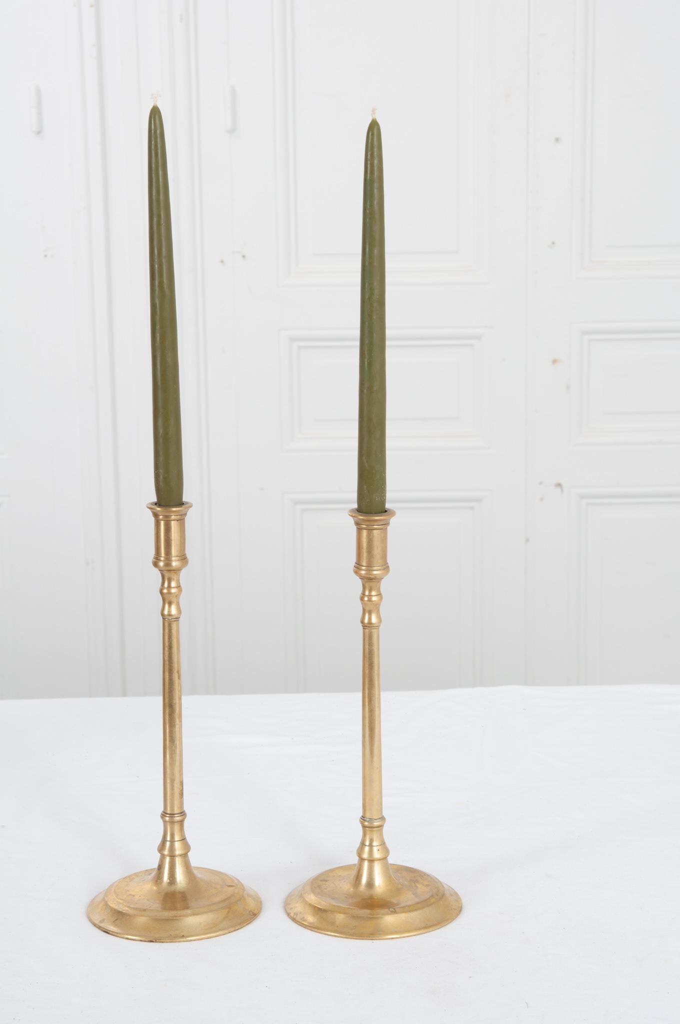 A sophisticated pair of 19th century brass candlestick holders from France. What they lack in detail they makeup for in antique elegance. Recently cleaned and polished they are in great condition with few signs of wear. Make sure to view the