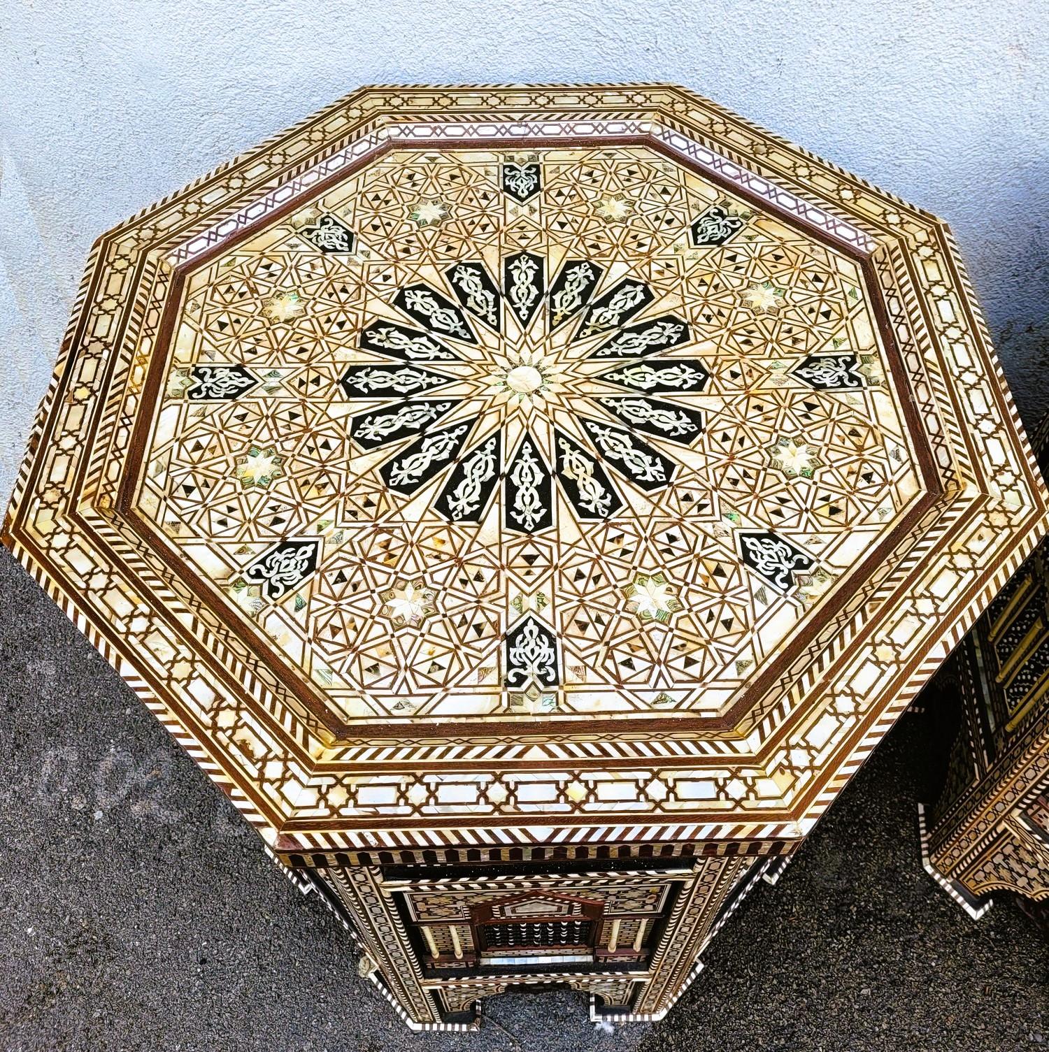 Pareja de mesas altas y grandes de pedestal hexagonal oriental, de madera, nácar y marquetería de hueso, ingeniosamente organizadas para crear una decoración con motivos geométricos

Raro en esta altura

Las patas están rematadas con arcos morunos,