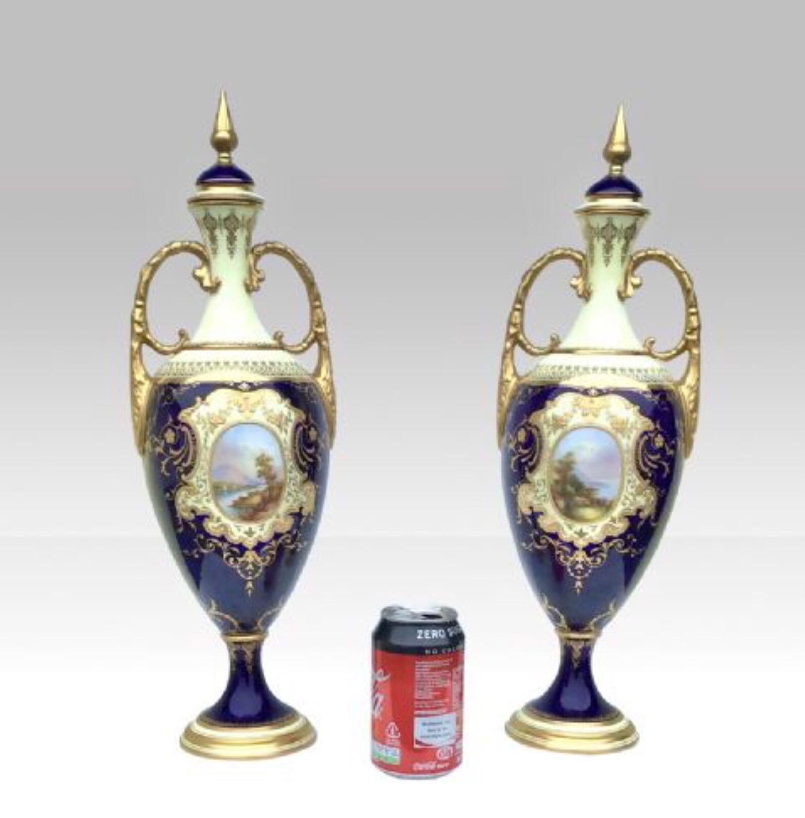 A magnificent pair of tall antique Coalport Porcelain vases, of baluster form with original covers and twin-scroll handles, painted with landscape panels on cobalt blue and lemon grounds highlighted in gilt, printed marks.
46.5cm high.