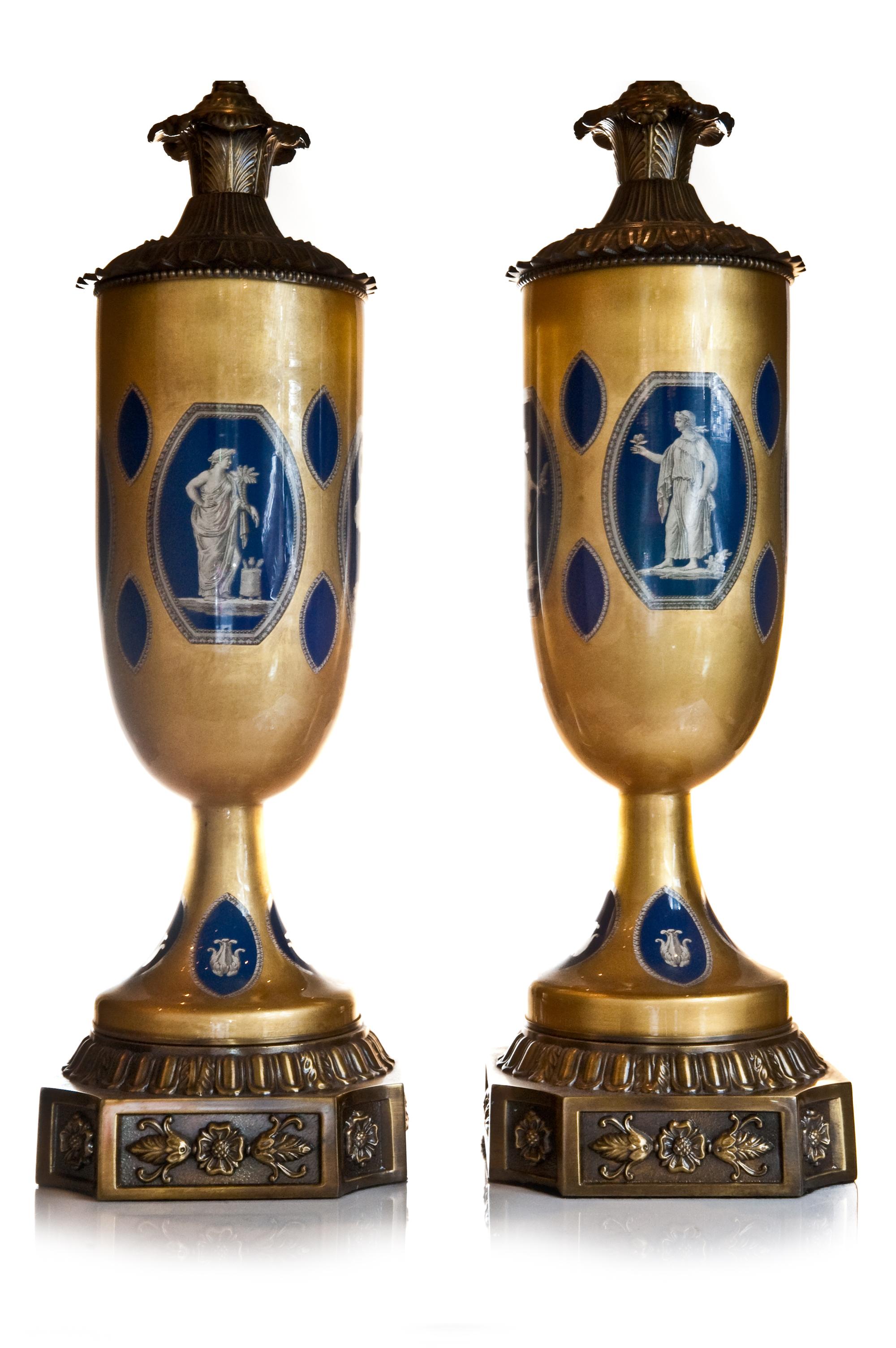 Paire de lampes de style Empire néoclassique français, montées sur un églomisé en bronze bleu lapis et doré, peintes et émaillées à la main. Chaque lampe unique est ornée de scènes figuratives et d'instruments de musique.