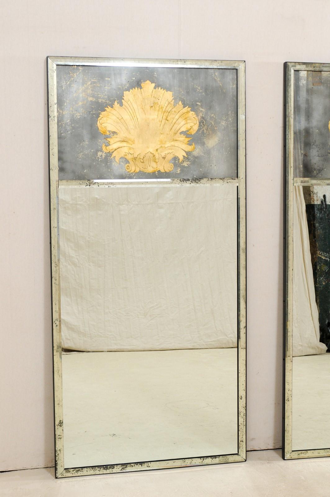 Paire de miroirs artisanaux avec des accents de feuilles d'acanthe en éventail en verre églomisé. Ces miroirs artisanaux de fabrication américaine, de forme rectangulaire et d'une hauteur d'environ 6,5 pieds, présentent deux panneaux (le miroir