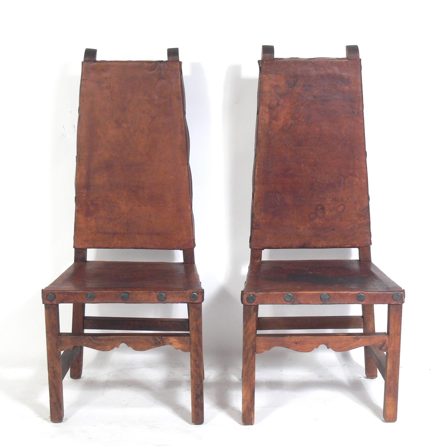 Pair of tall back Mexican leather chairs , Mexico, circa 1950s. They retain their original distressed patina. They would be perfect in a California or Mexican hacienda or anywhere you want the organic rustic vibe of aged leather and wood.