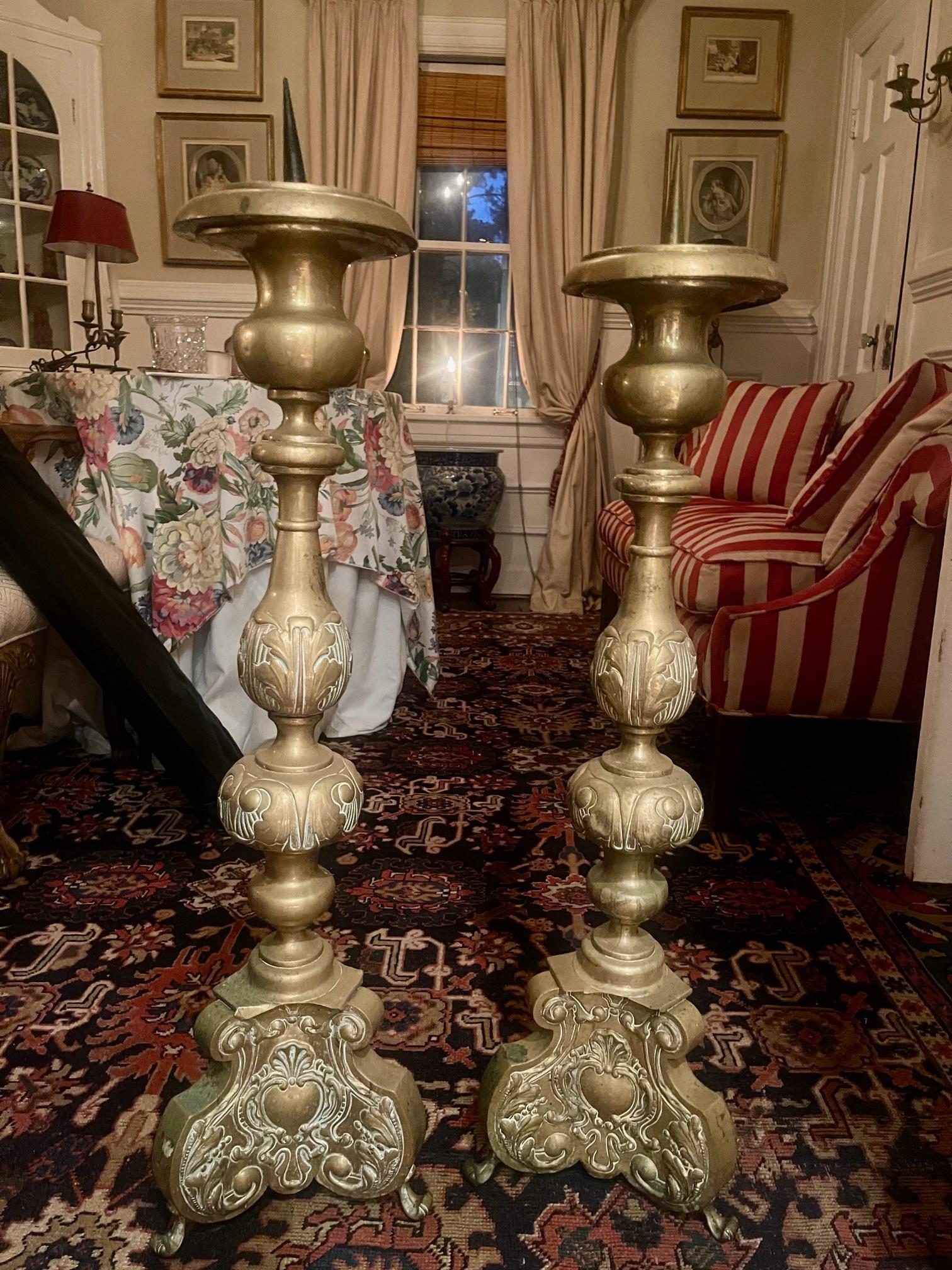 Coppia di alti grilli o candelabri da chiesa in ottone repousse, XIX secolo.  Uno dei due rami è più alto di 1 pollice rispetto all'altro.